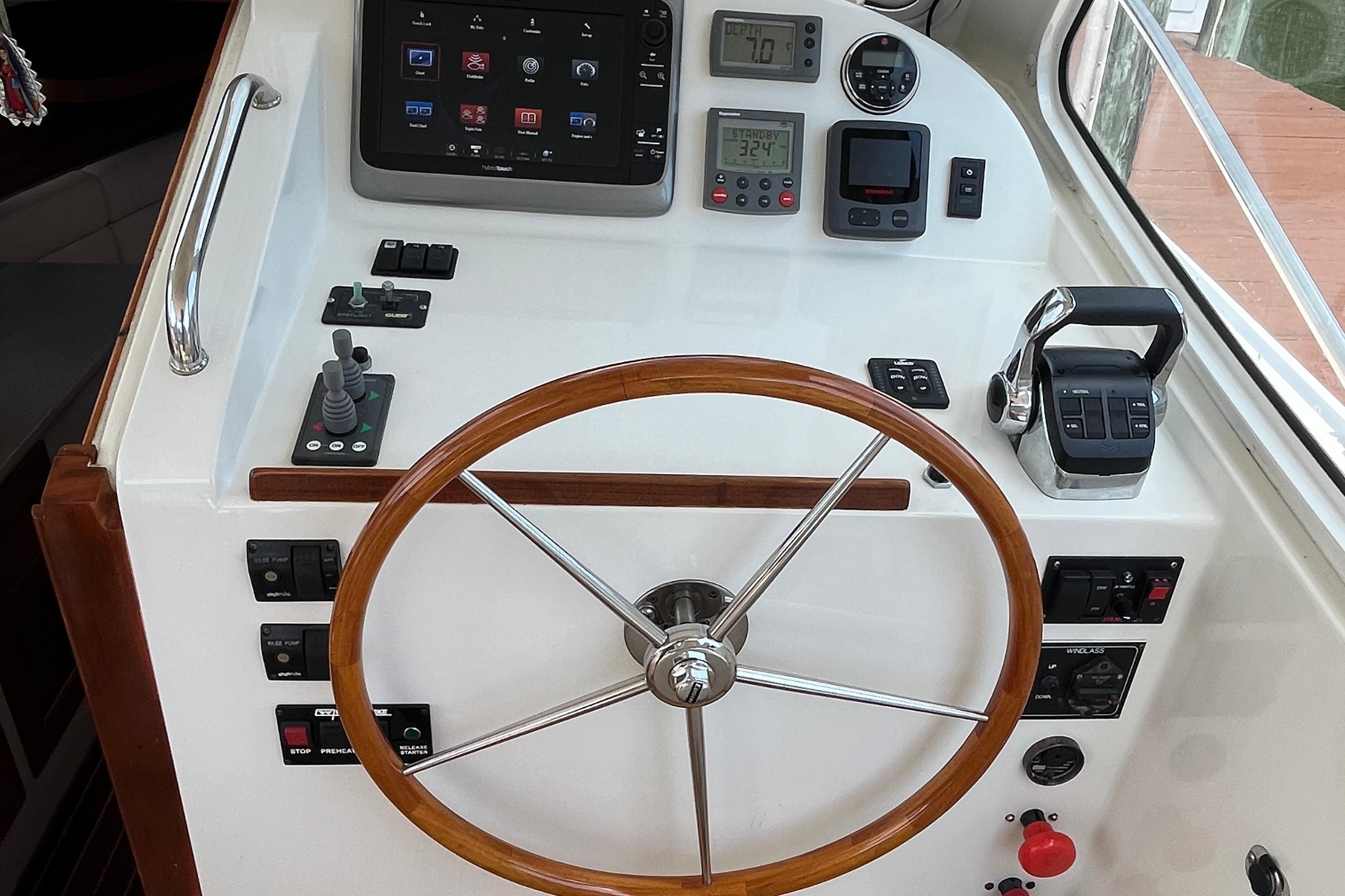 2006 MJM 34z helm with wooden steering wheel and modern navigation controls.