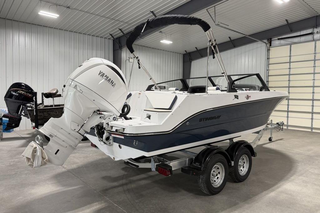 2027 Stingray 20 SBX boat with Yamaha outboard motor in a garage setting.