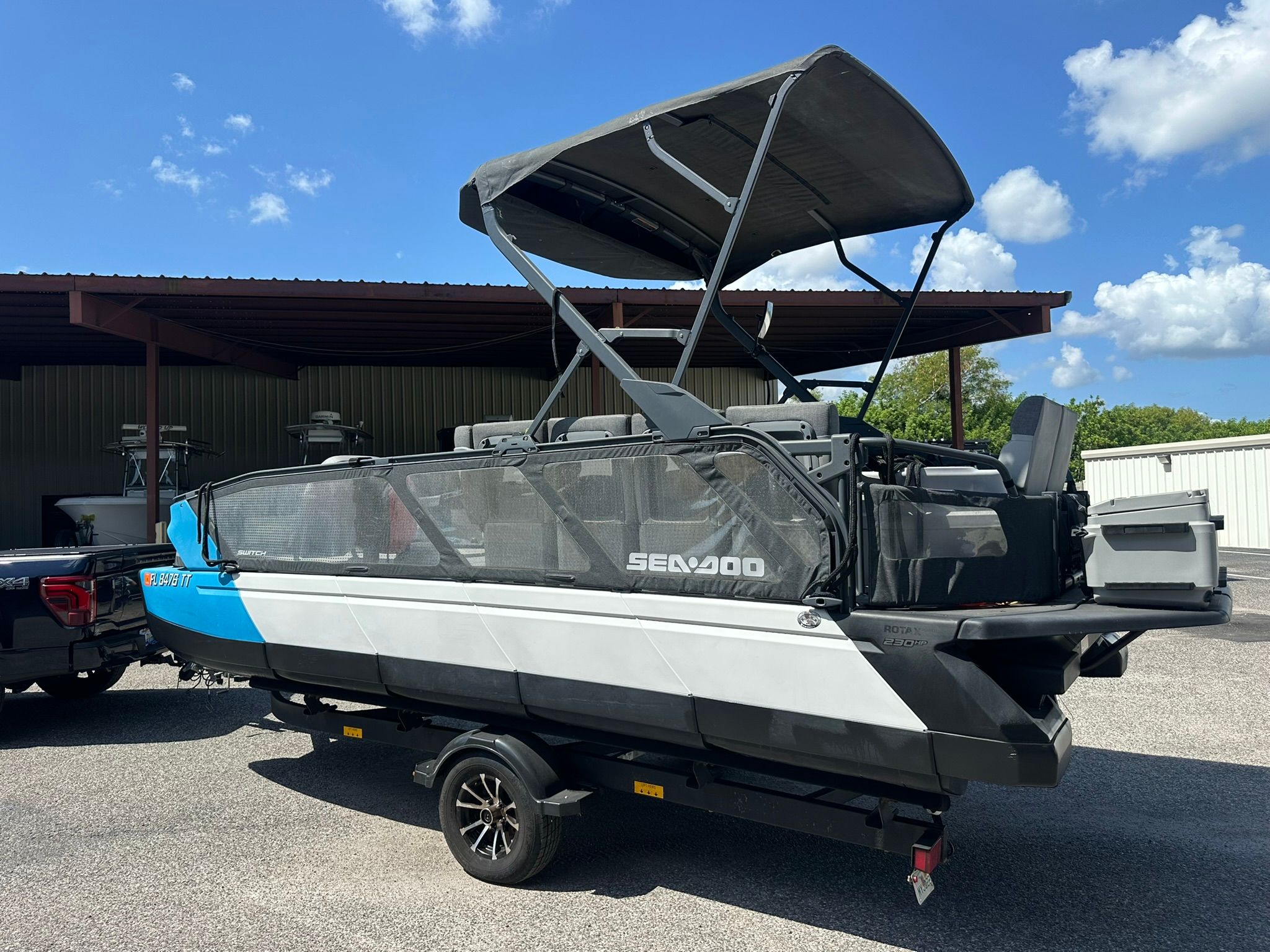 A 2023 Sea-Doo 21 SWITCH SPORT on a trailer, featuring a black canopy and blue accents.