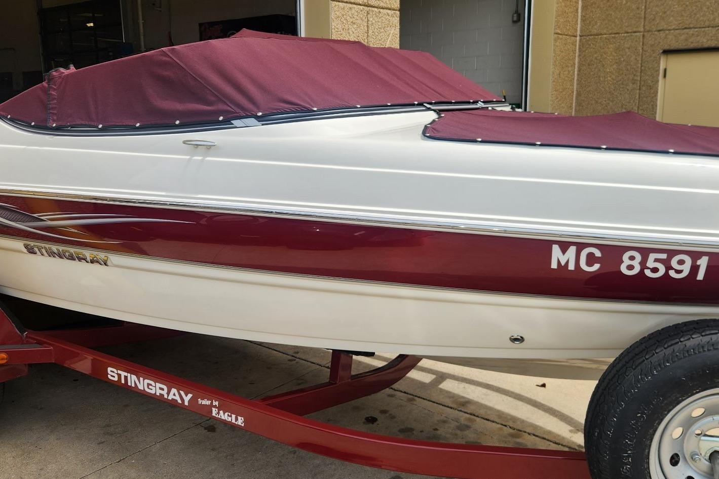 2013 Stingray 198 LX boat with maroon cover on a trailer.
