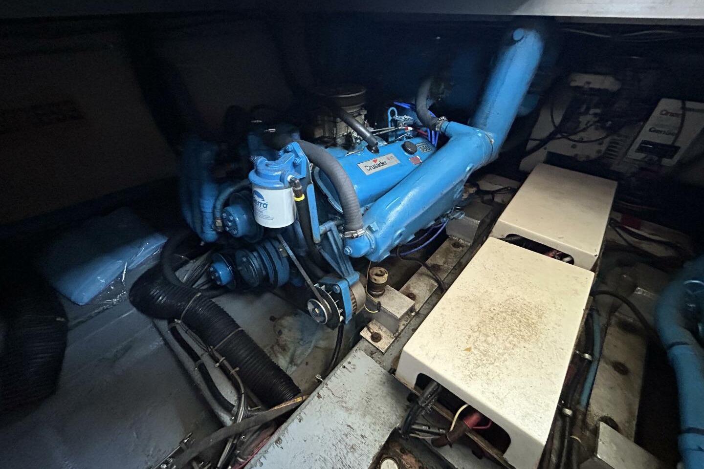 Engine room of 1984 Hatteras 36 Convertible boat, featuring blue machinery and components.