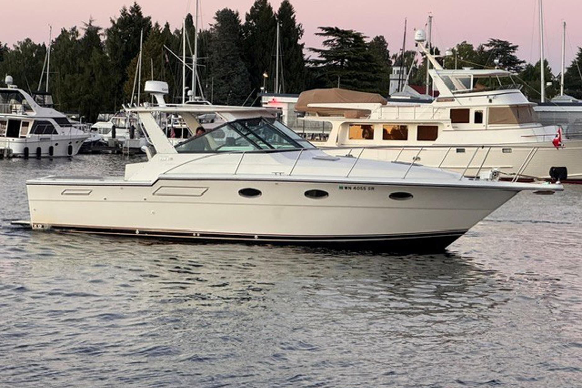 1988 Tiara Yachts 3300 Open cruising in a marina at sunset.