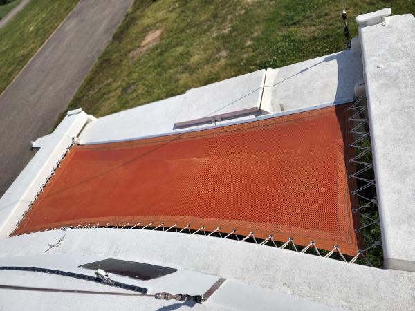 1985 Crowther Buccaneer catamaran with orange netting and white deck, viewed from above.