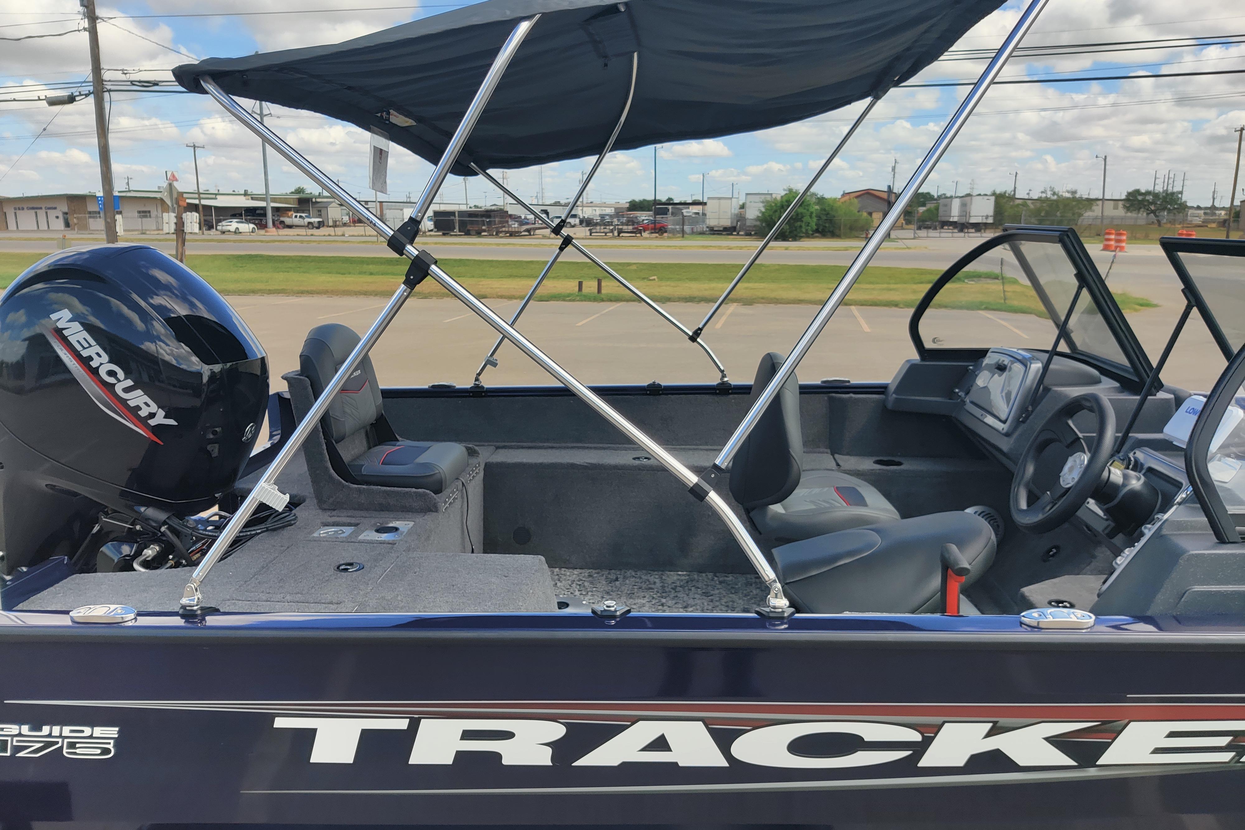2026 Tracker Pro Guide V-175 Combo boat with Mercury engine and canopy, parked outdoors.