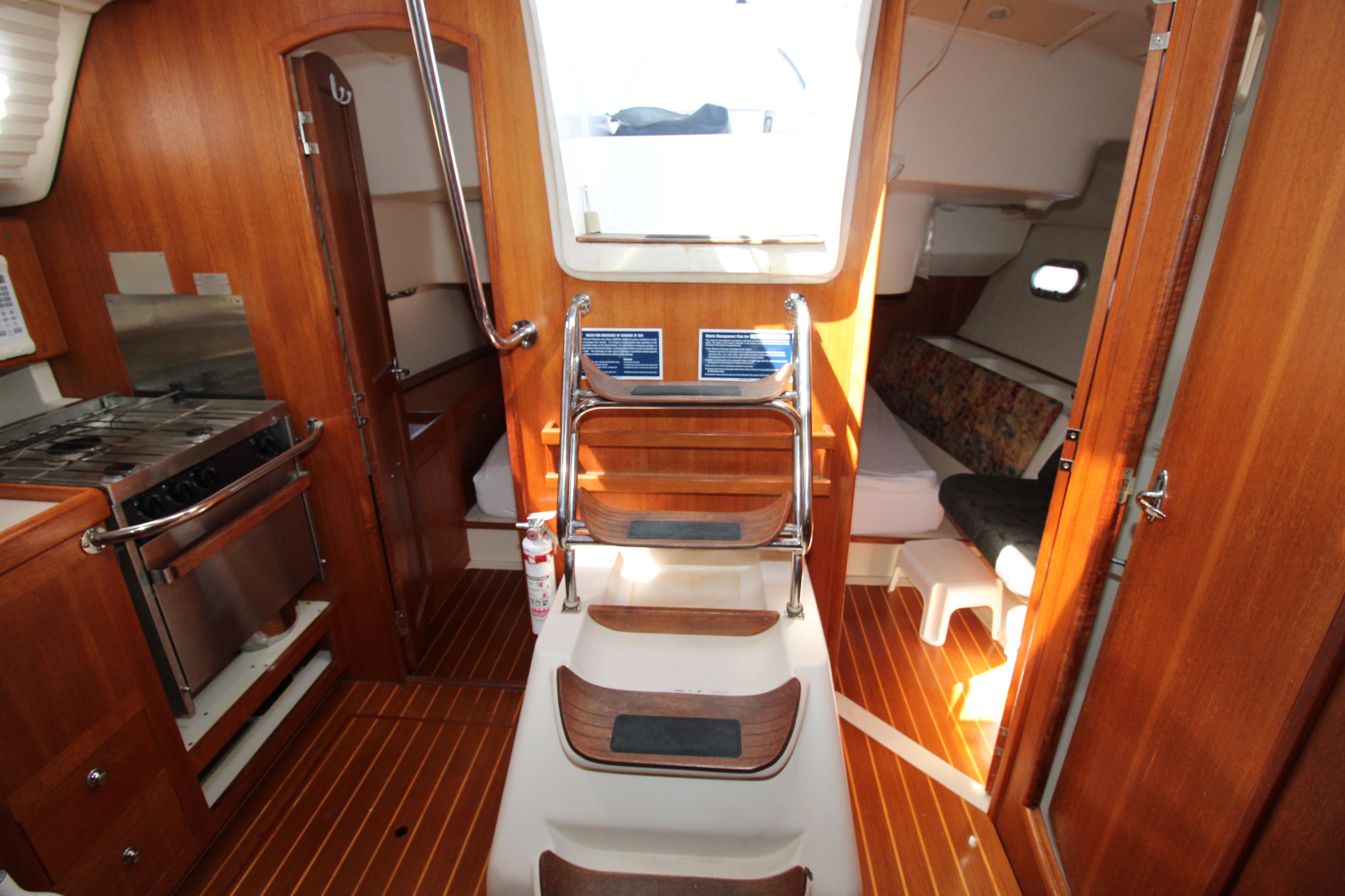 Interior of 2002 Hunter 410 sailboat with wood finish and compact kitchen area.