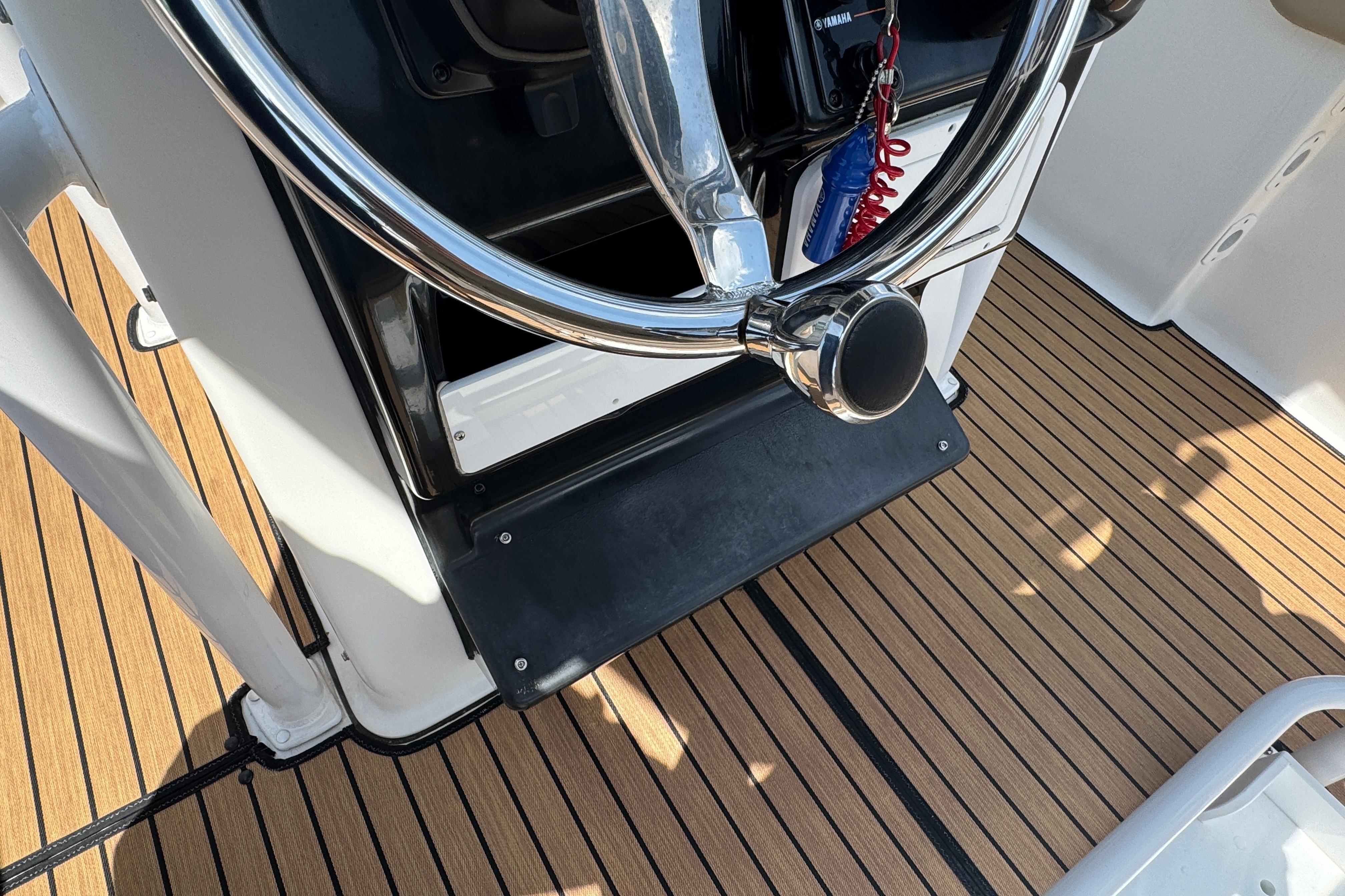 Steering wheel of 2016 Tidewater 230 LXF boat with teak flooring.