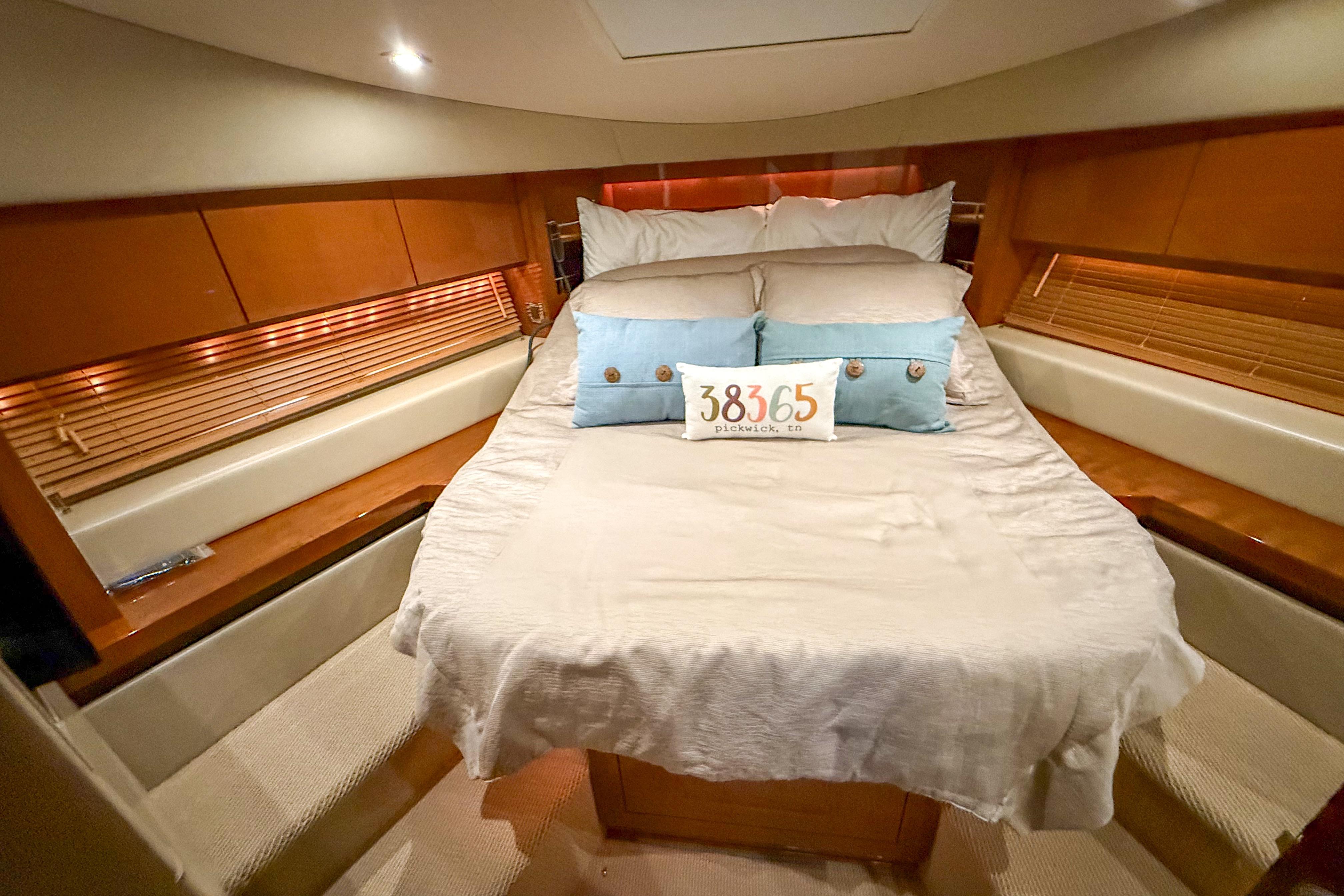 Luxurious 2016 Sea Ray Sundancer 510 yacht bedroom with cozy bedding and elegant wood accents.