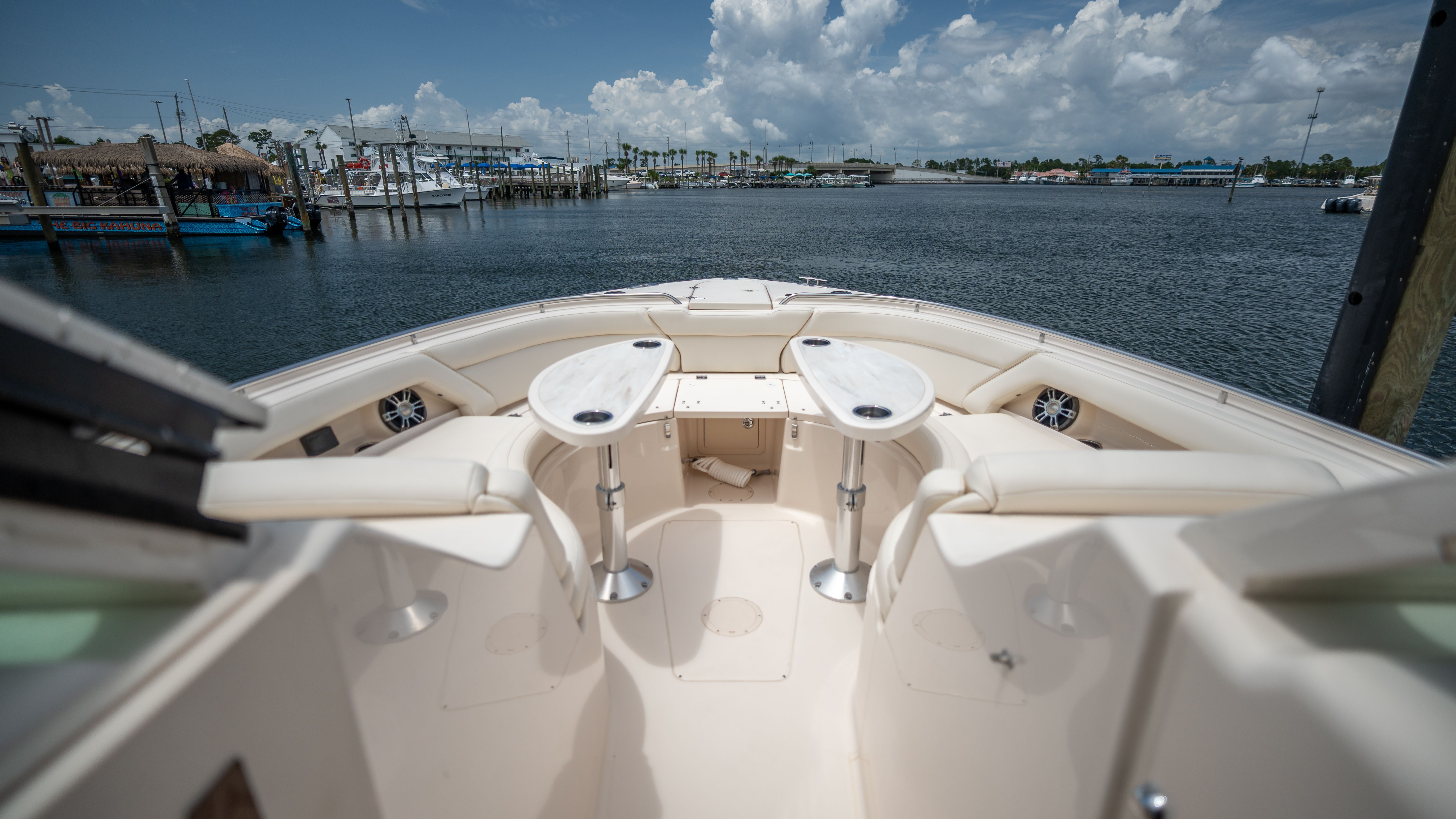 2019 Grady-White 375 Freedom: Spacious deck with seating and tables, overlooking a marina.