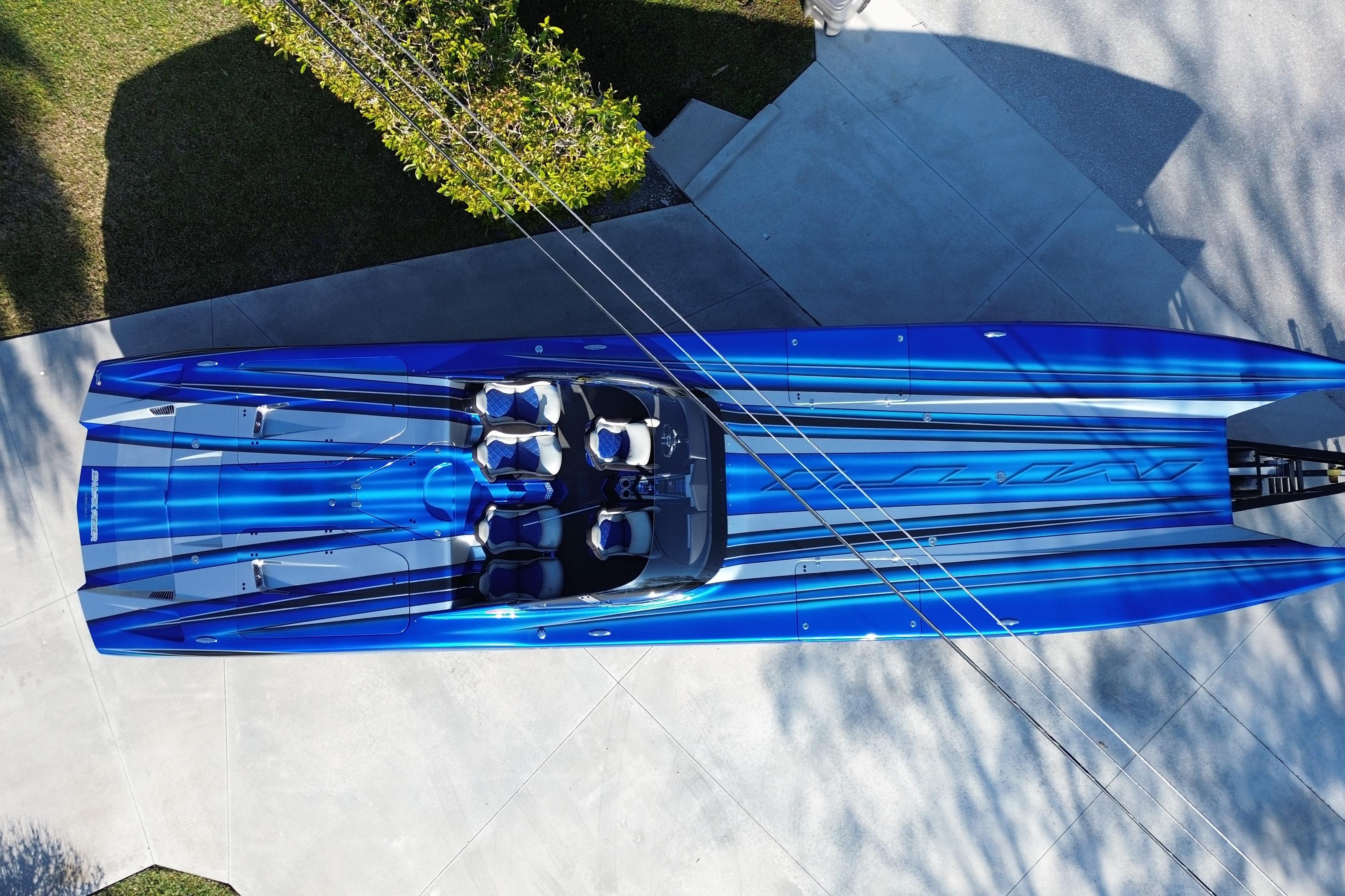 Aerial view of a 2016 MTI 44 RP speedboat with blue and silver stripes.