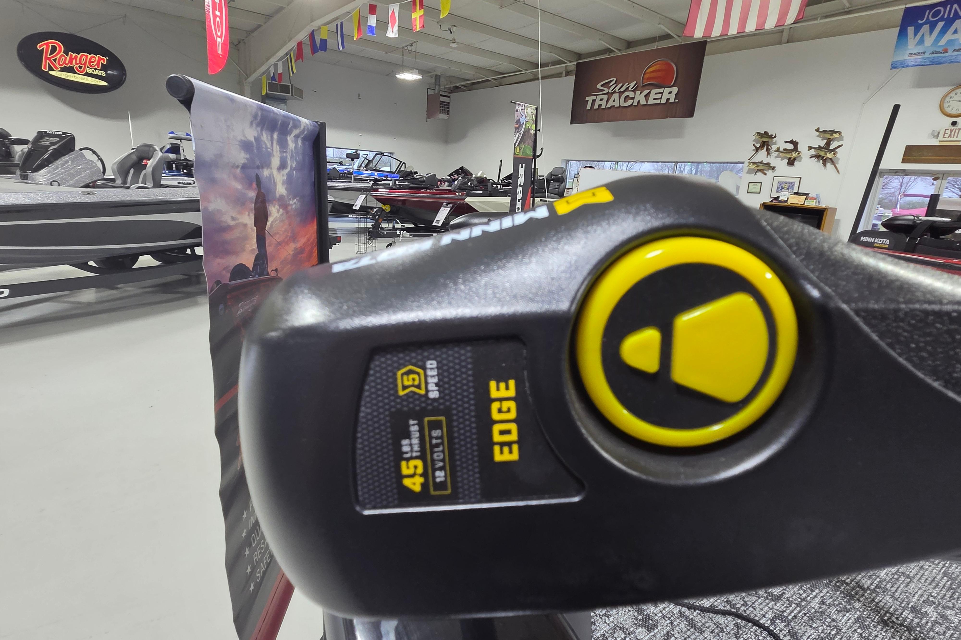 2026 Tracker Pro Team 175 Crappie Edition boat in showroom with motor detail.