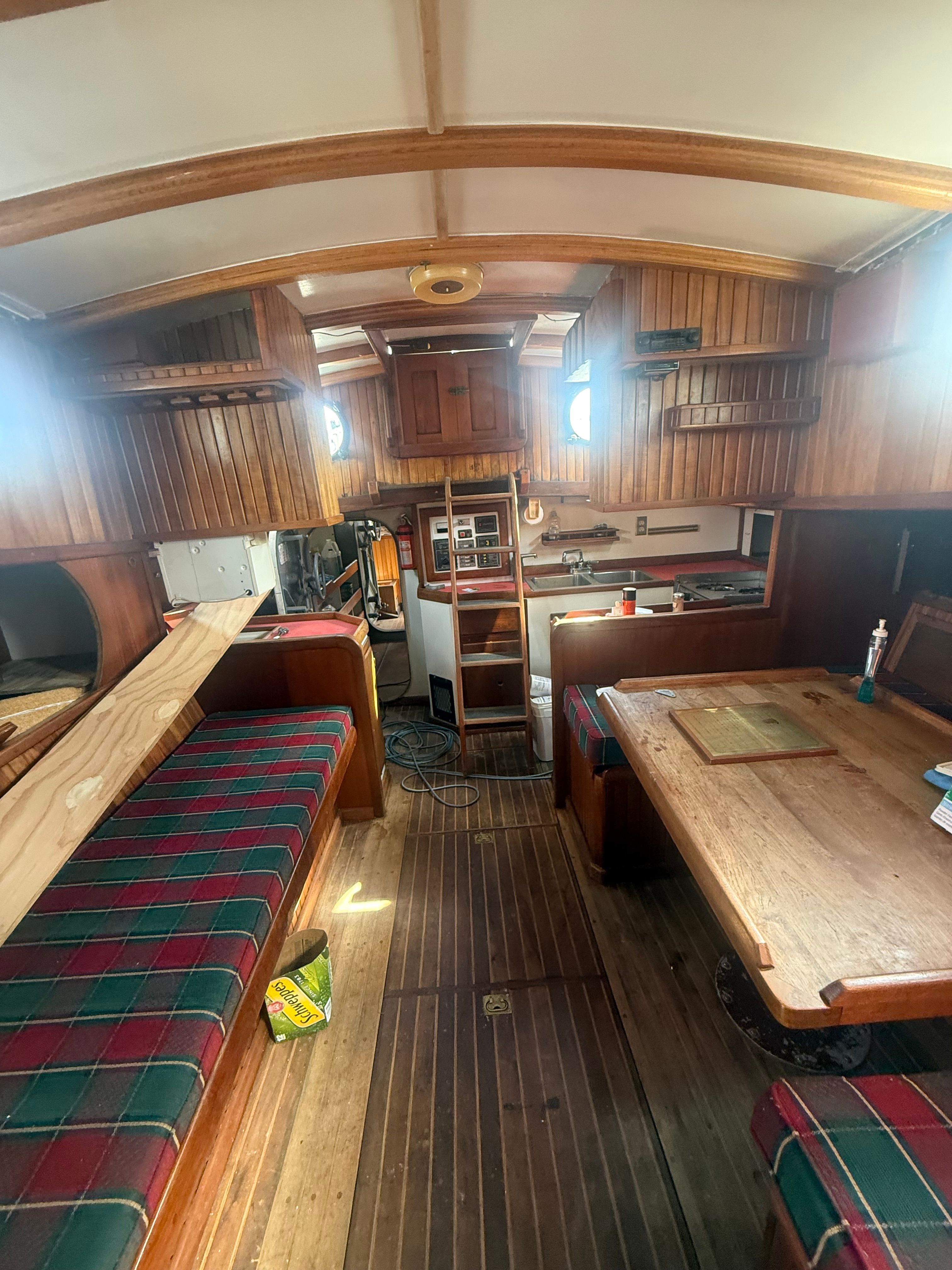 Interior of a classic sailboat with wooden fittings and cozy seating areas.
