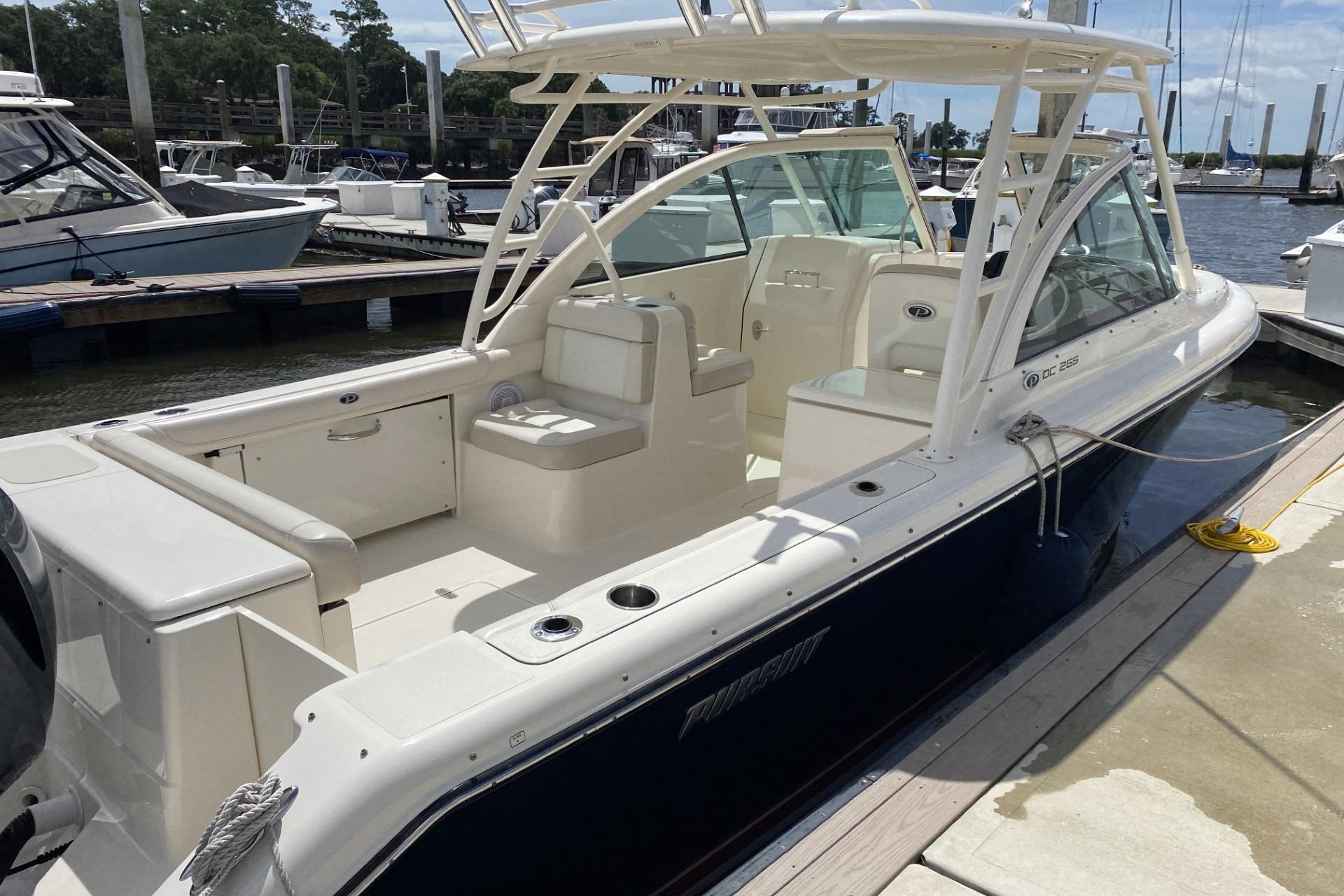 2013 Pursuit DC 265 Dual Console boat docked at marina, featuring spacious seating.