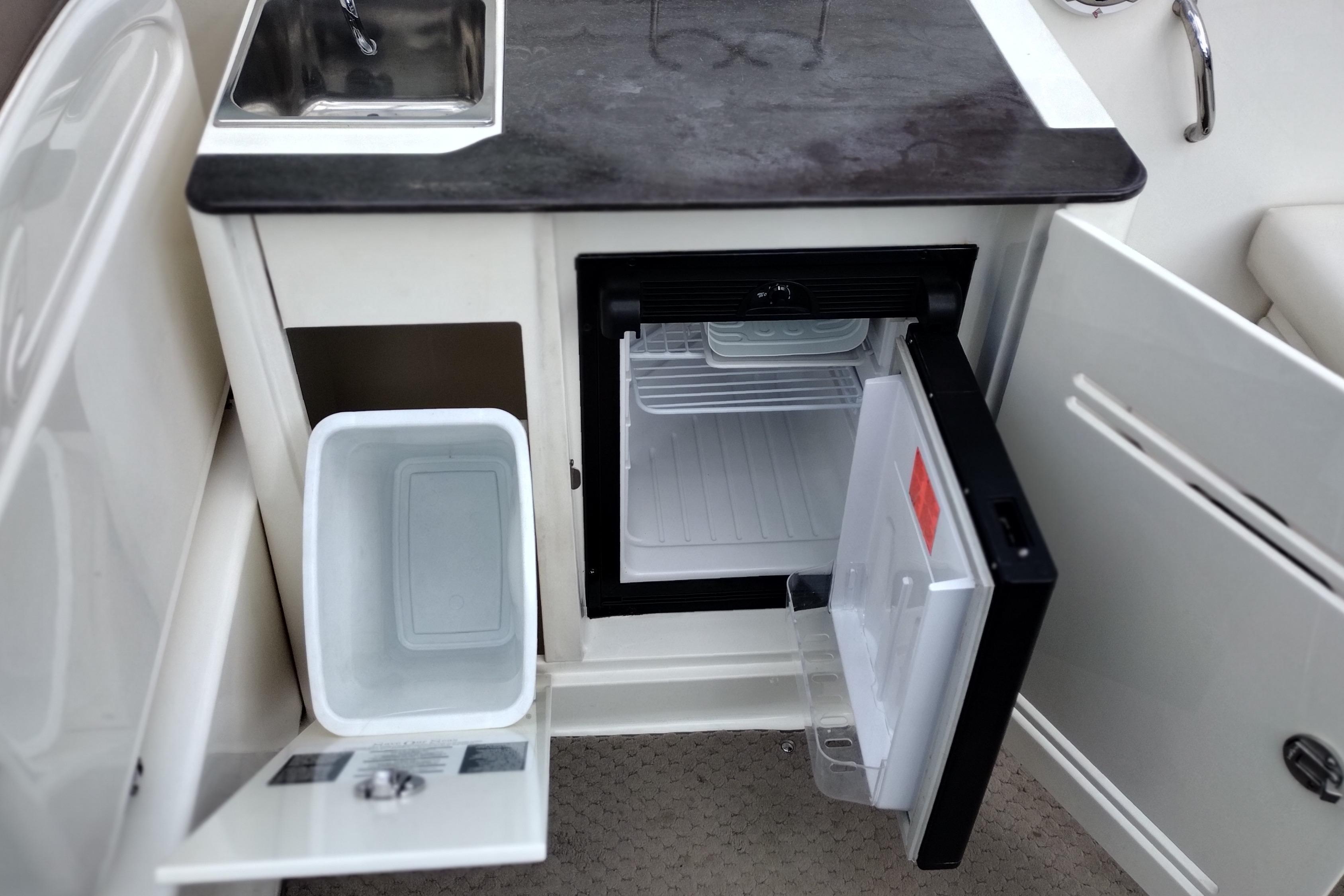 2013 Sea Ray 300 SLX boat kitchenette with sink, mini fridge, and storage.