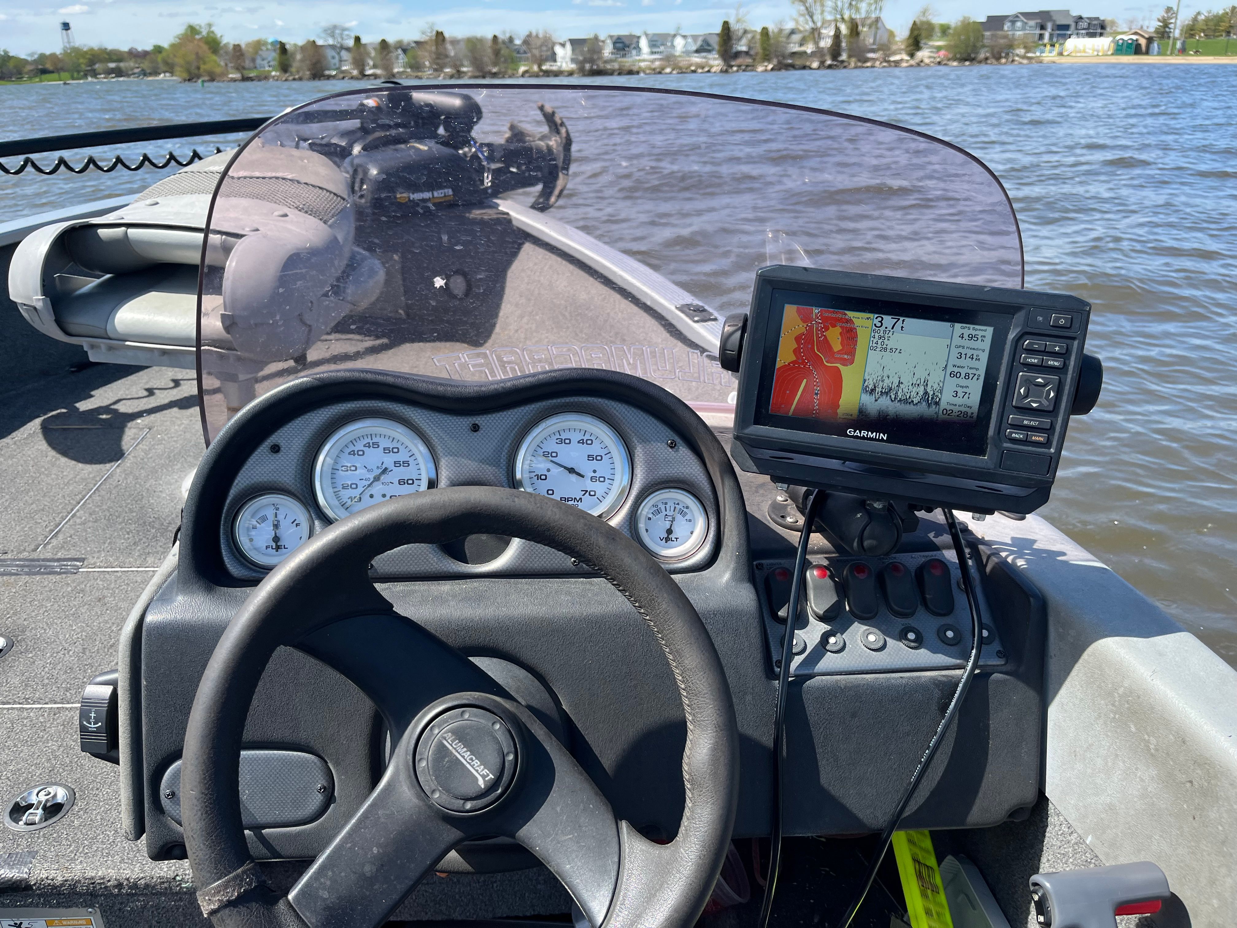 The image shows the cockpit of a 2005 Alumacraft Navigator 175CS boat on the water.