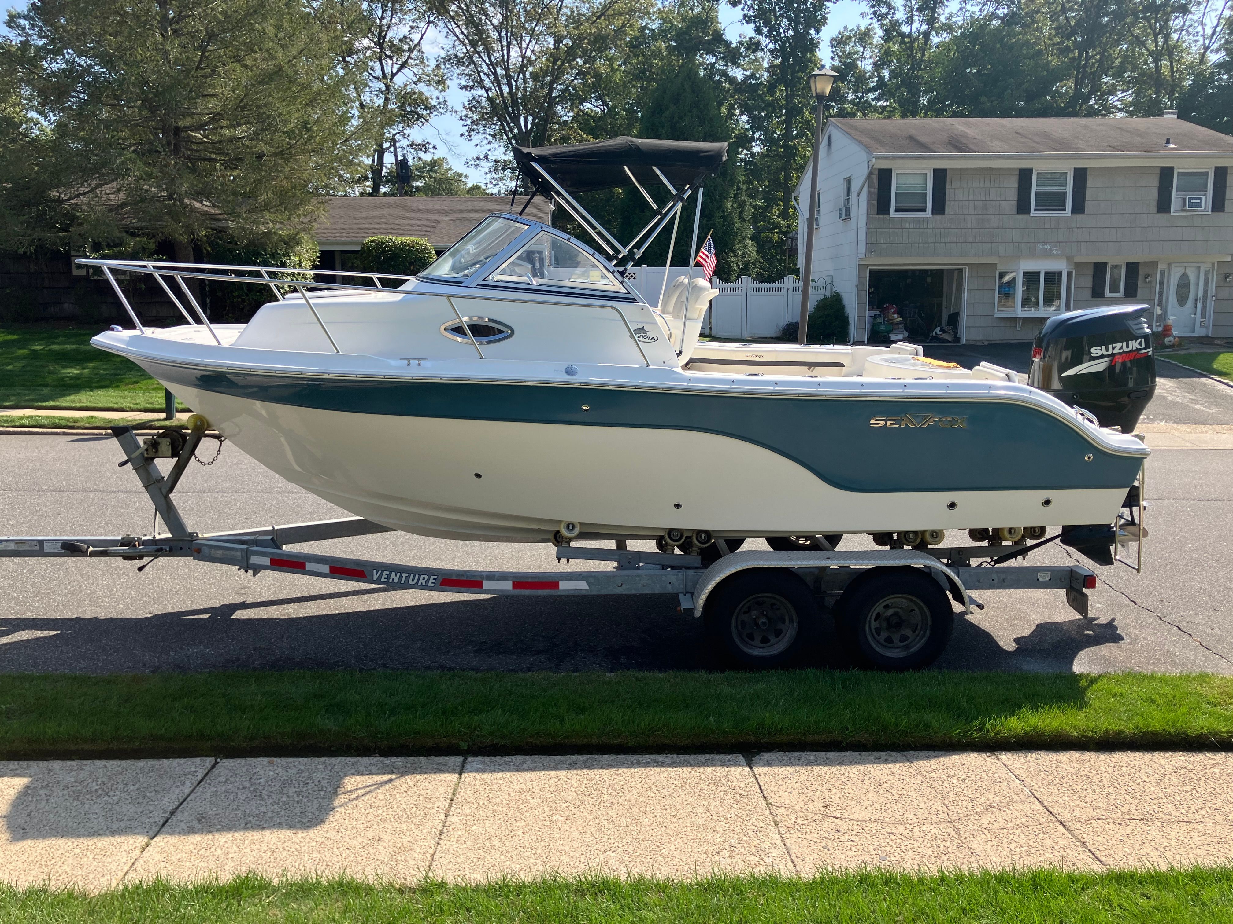2010 Custom 216wa Pro boat on trailer in residential area.