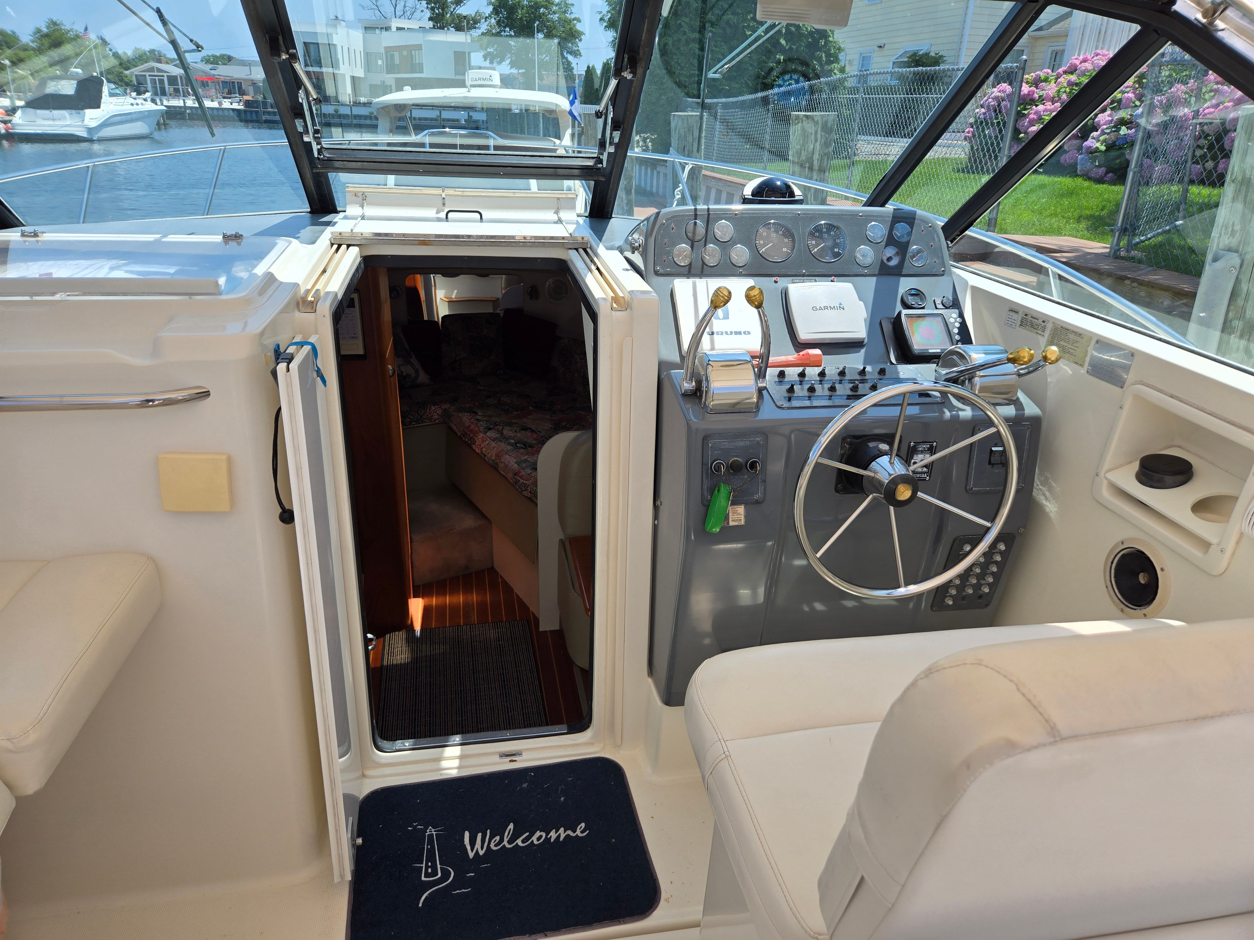 The cockpit of a 1997 Tiara Yachts Open with helm and cabin access.