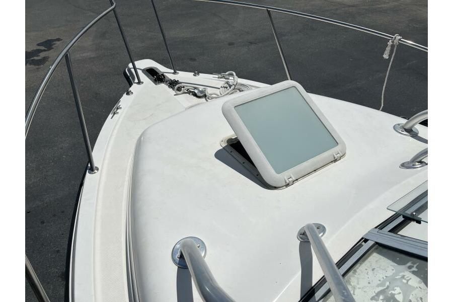 Bow view of 2006 Century 2400 Walk-Around boat with hatch and railing.