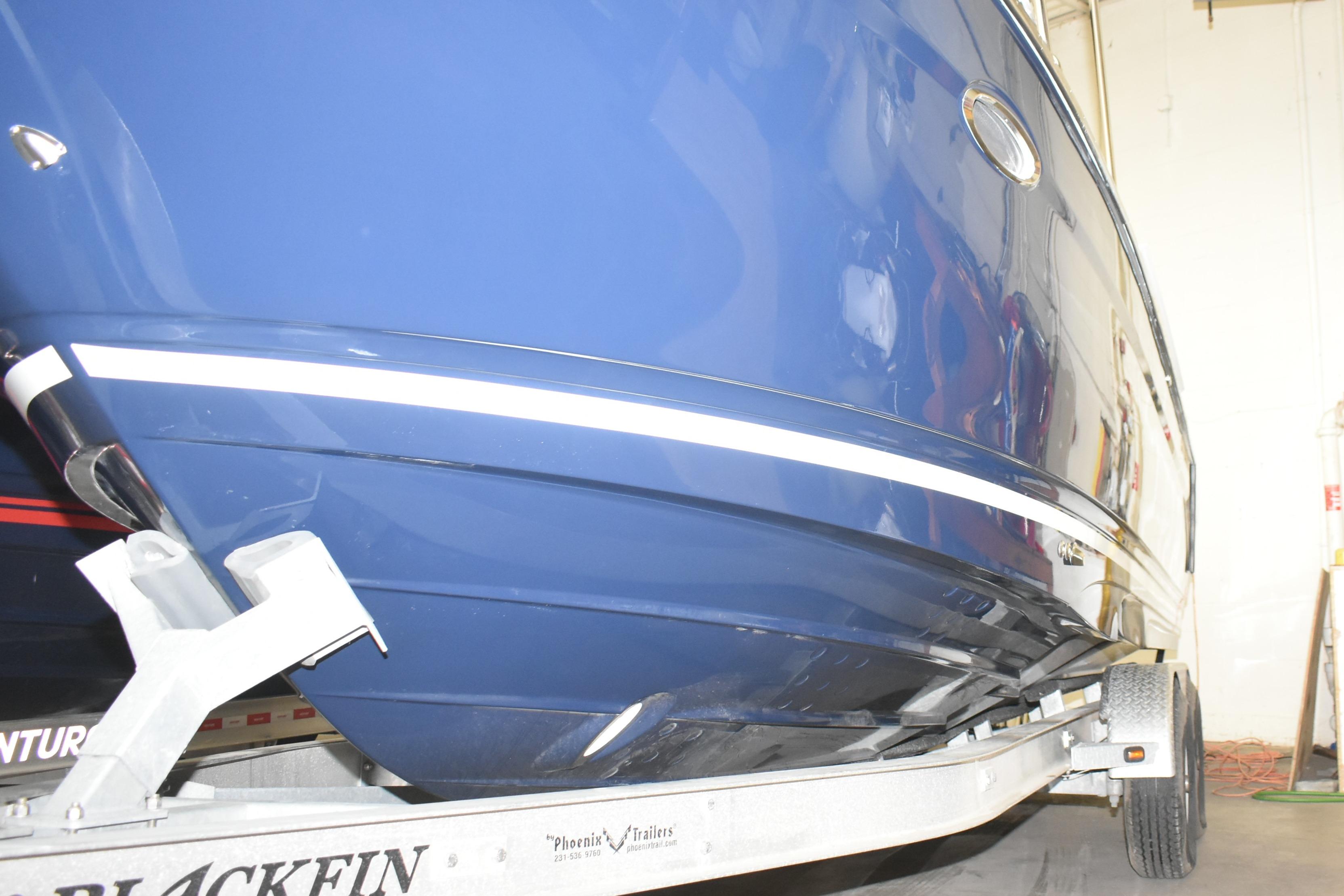 2026 Cutwater C-248 Coupe boat on trailer, blue hull, indoor setting.