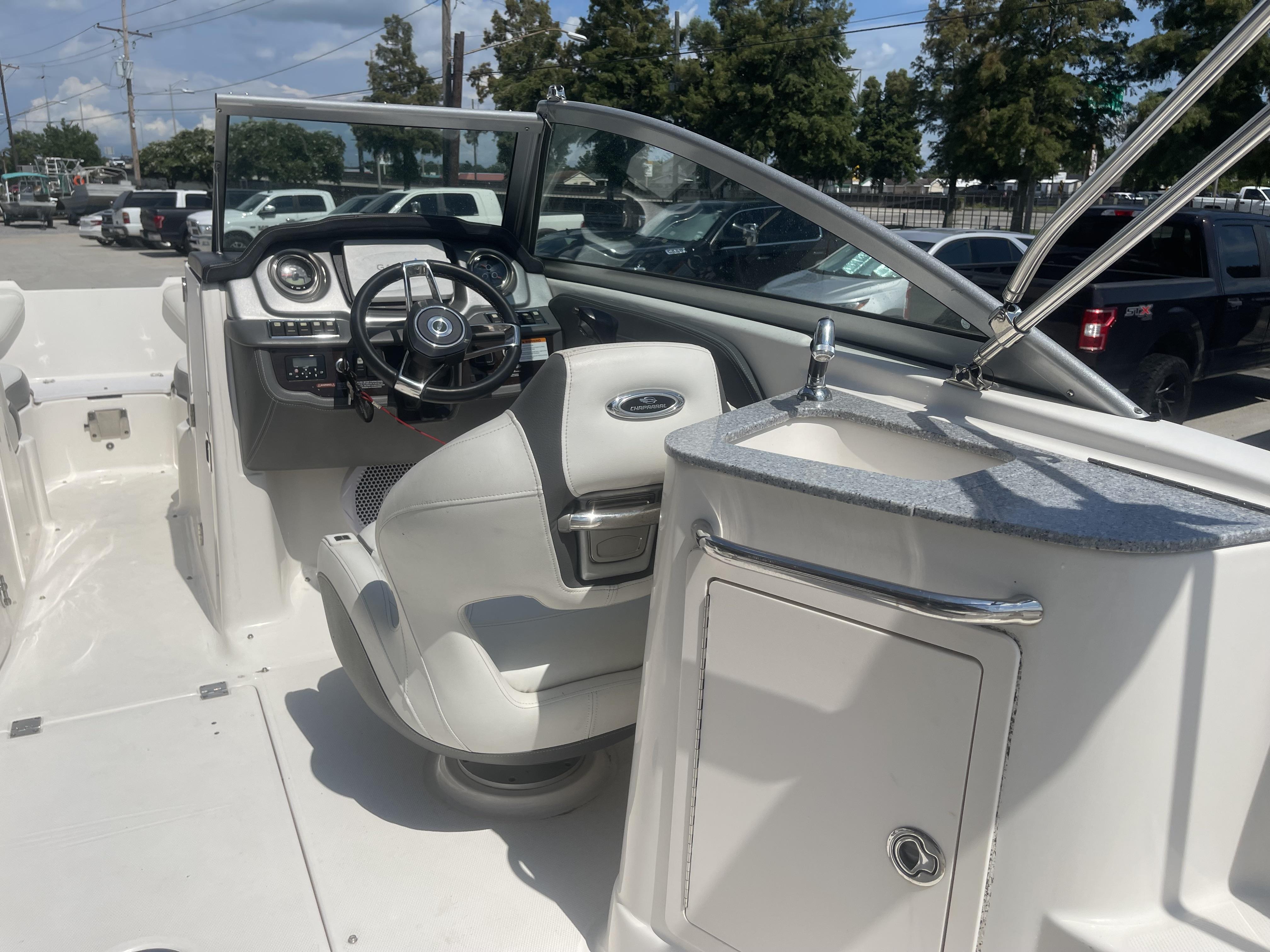 2014 Chaparral Sunesta 224 boat interior with steering wheel and sink.