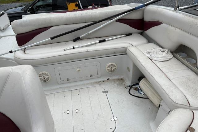 2004 Crownline 288 BR boat interior with white and maroon seating, fishing rods, and storage compartments.