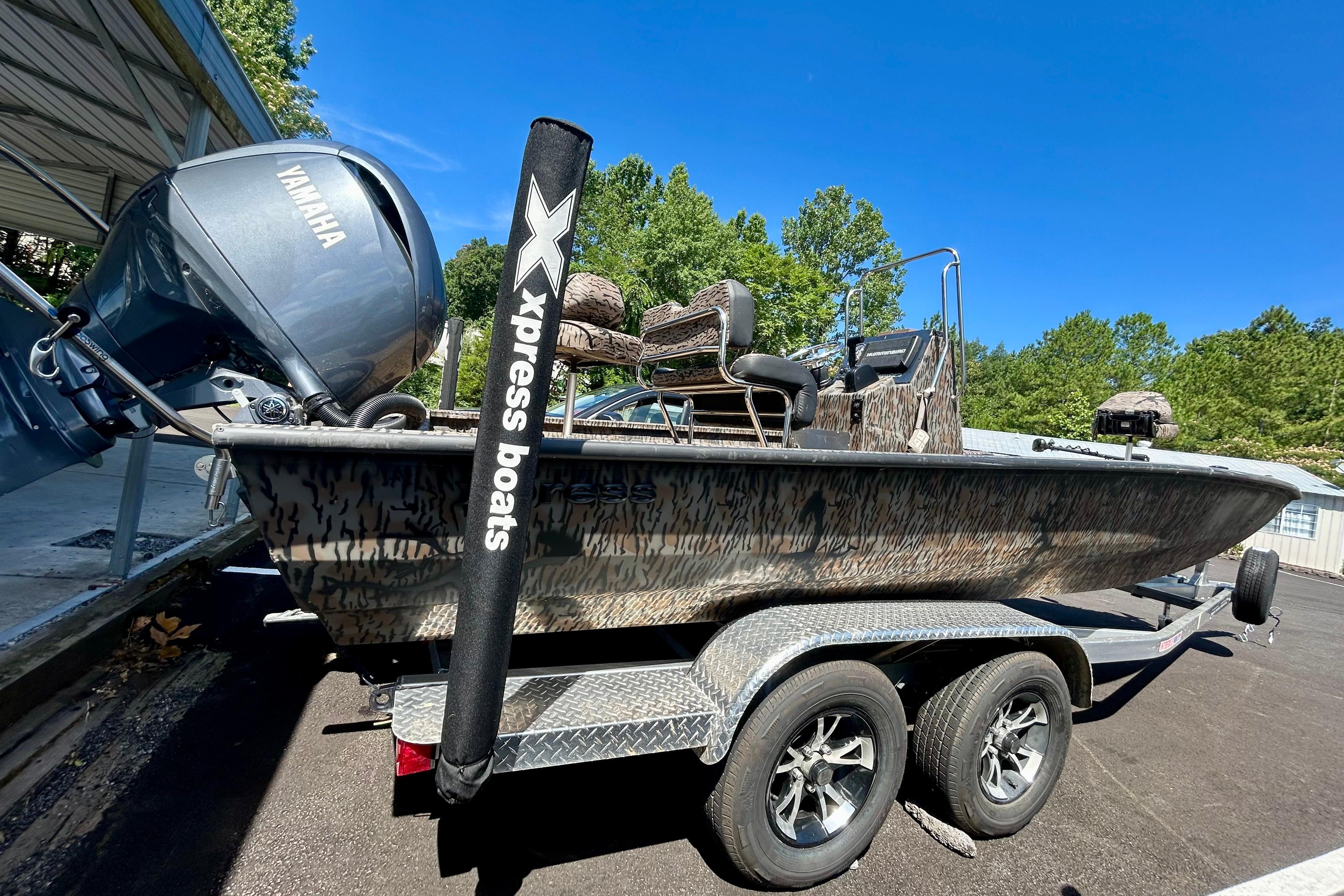 2025 Xpress H22B Bay boat with Yamaha engine on a trailer, parked outdoors.