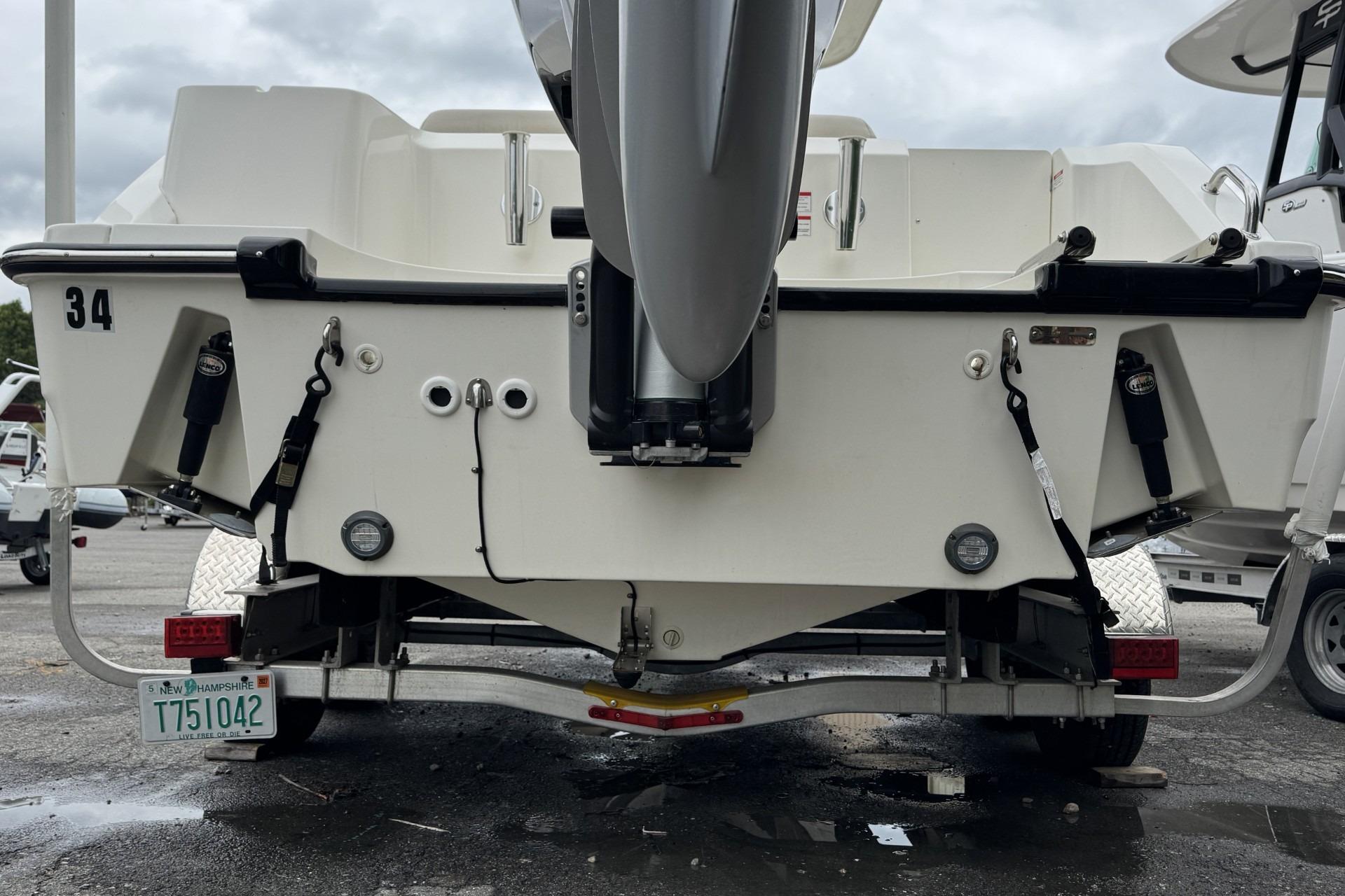 2024 Boston Whaler 230 Outrage boat rear view, showcasing motor and trailer details.