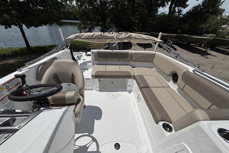 2026 Tahoe 2150 boat interior with beige seating, steering wheel, and lake view.