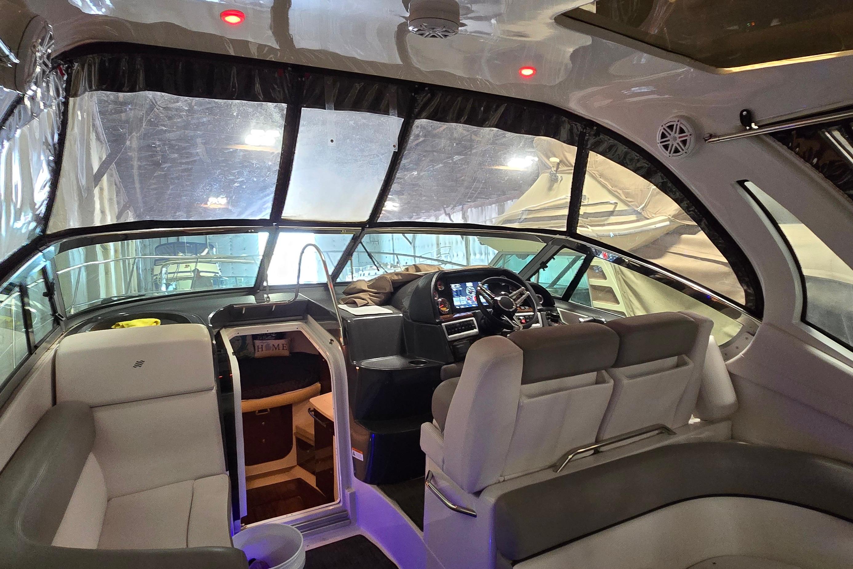 Interior of a 2018 Four Winns V355 boat, featuring a modern helm and seating area.