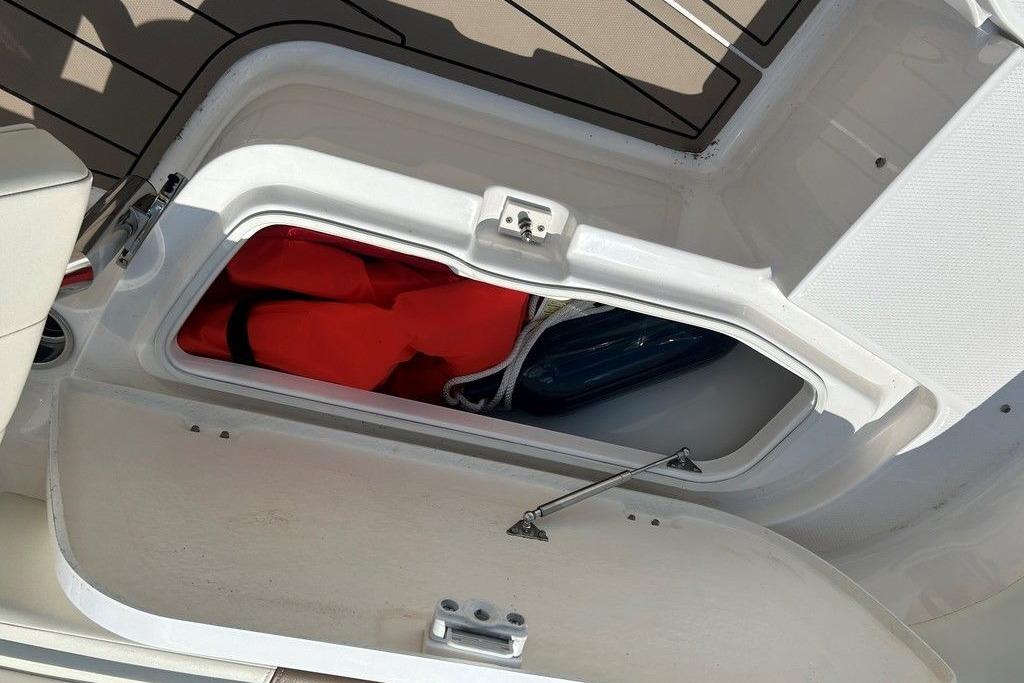 Open storage compartment on 2017 Robalo R200ES boat with life jackets inside.