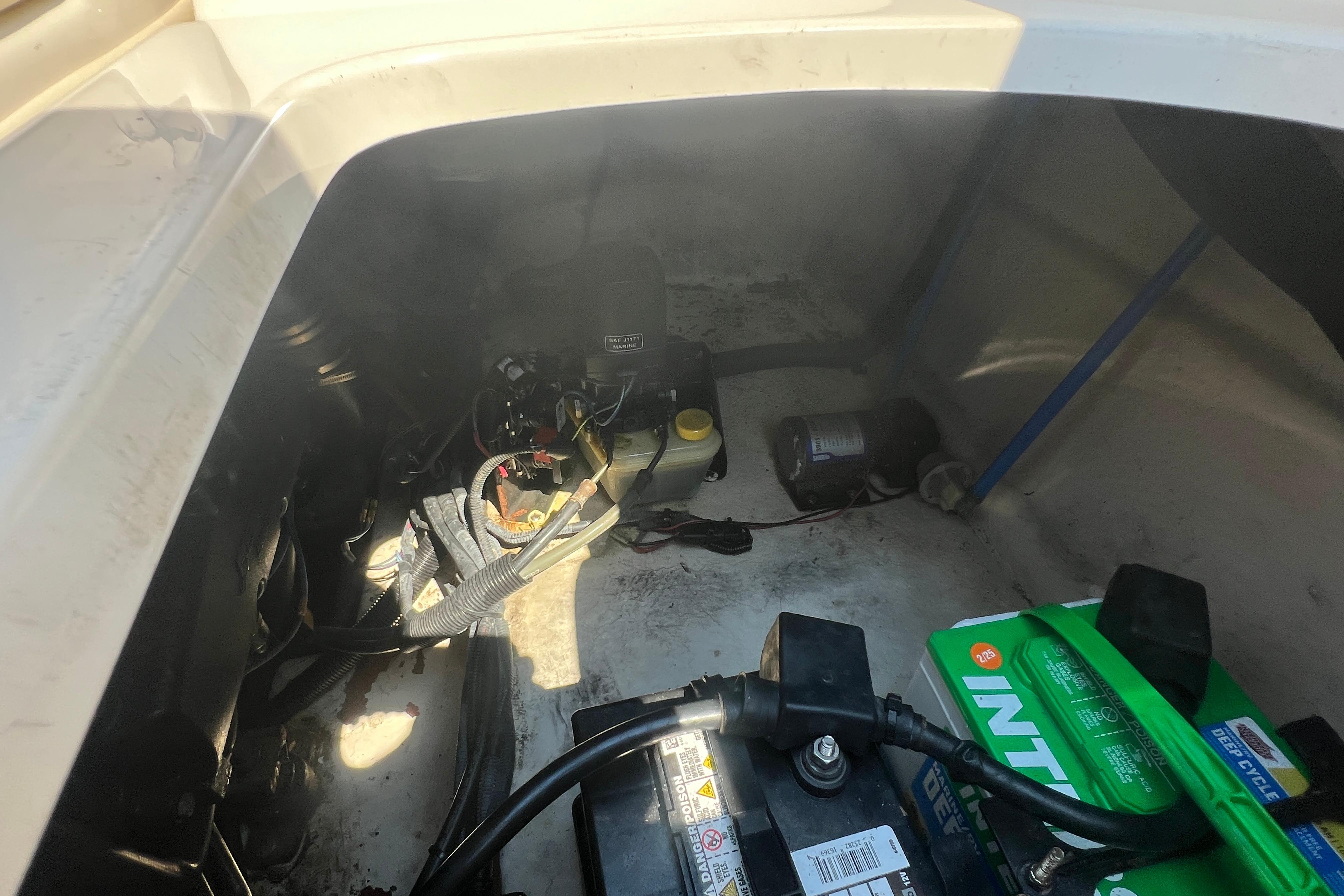 Engine compartment of a 2005 Sea Ray 240 Sundeck with visible battery and wiring.