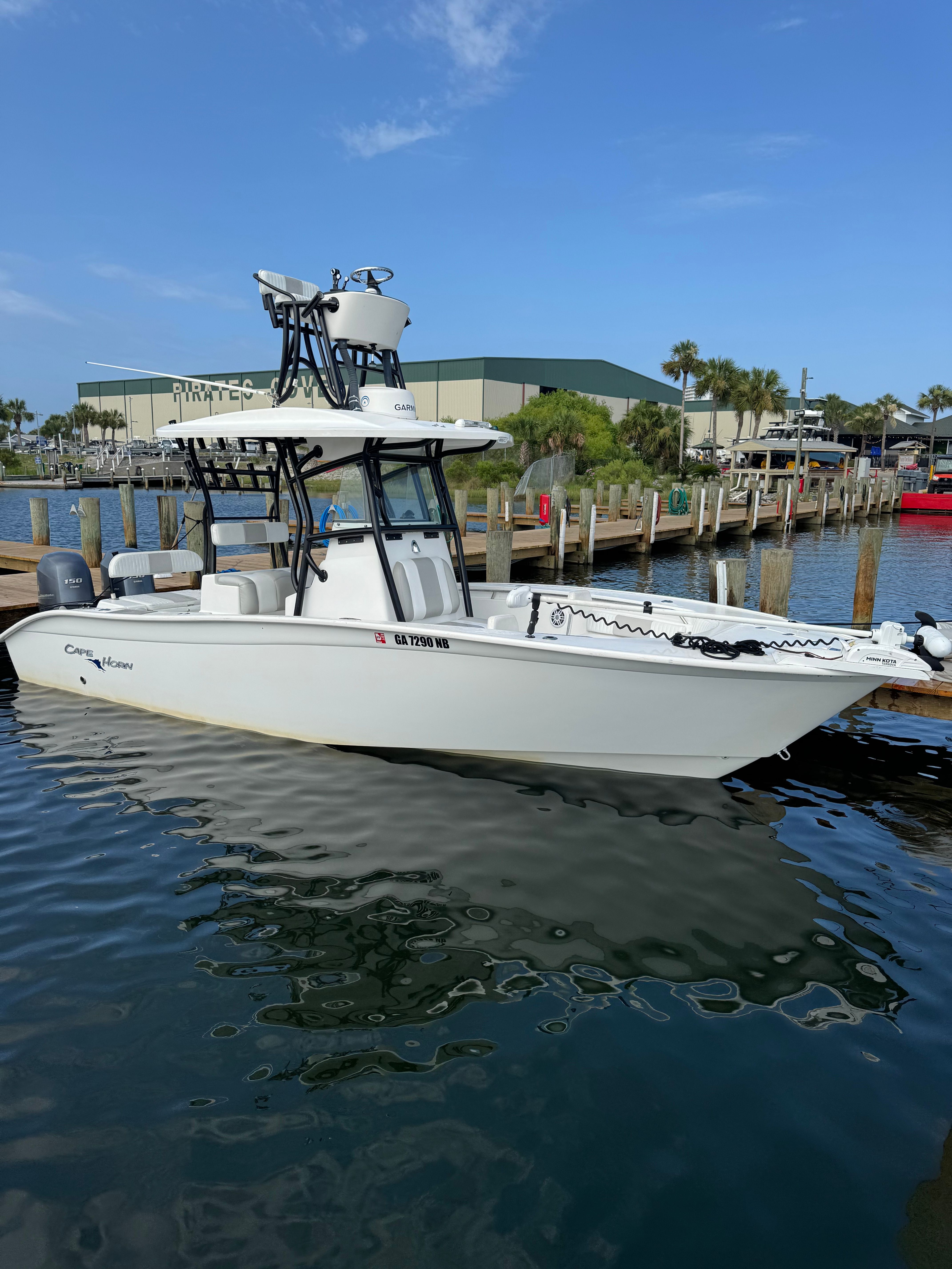 A white 2014 Cape Horn 24XS boat is docked on the water.