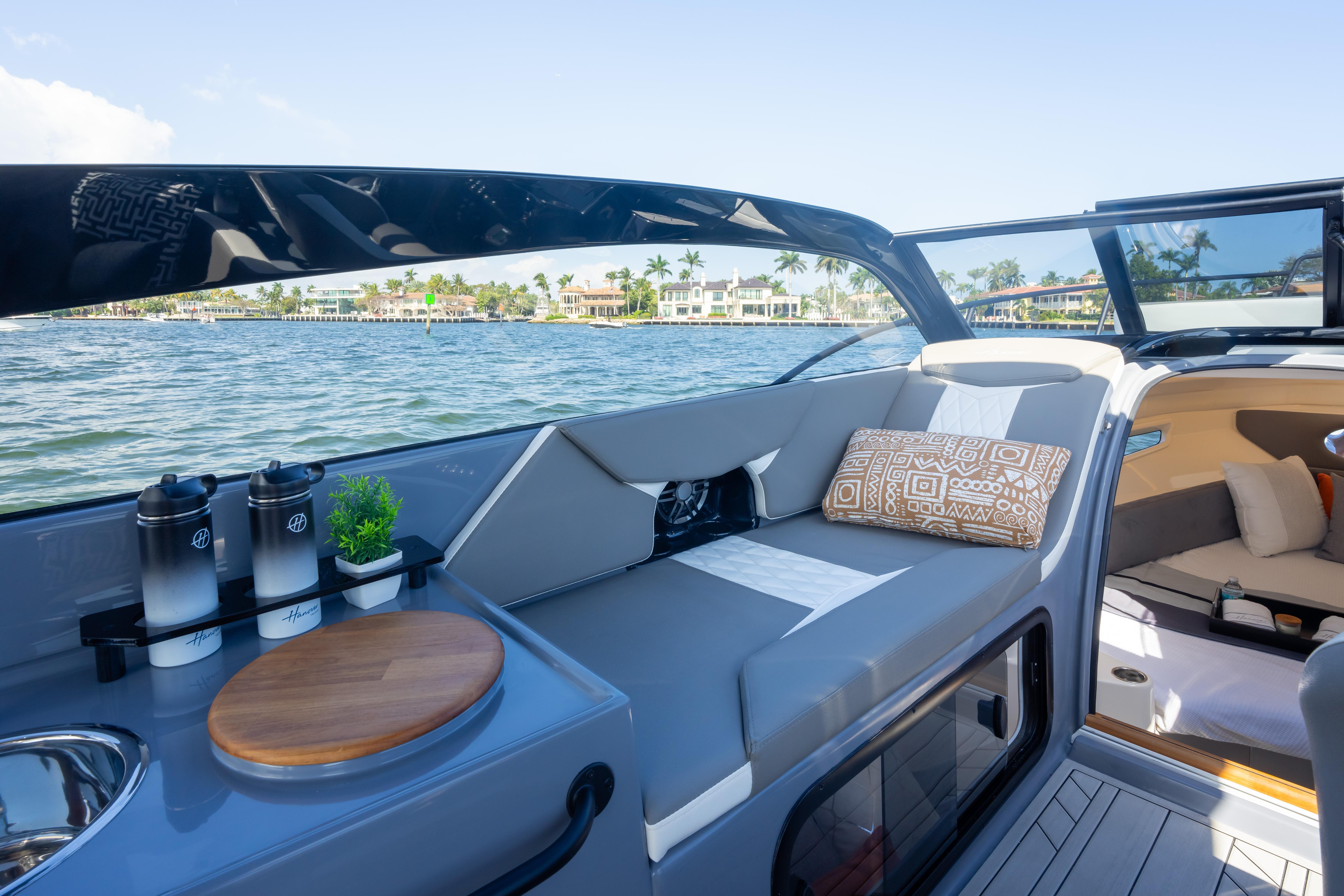 Luxurious 2026 Hanover 305 boat interior with comfortable seating and scenic waterfront view.