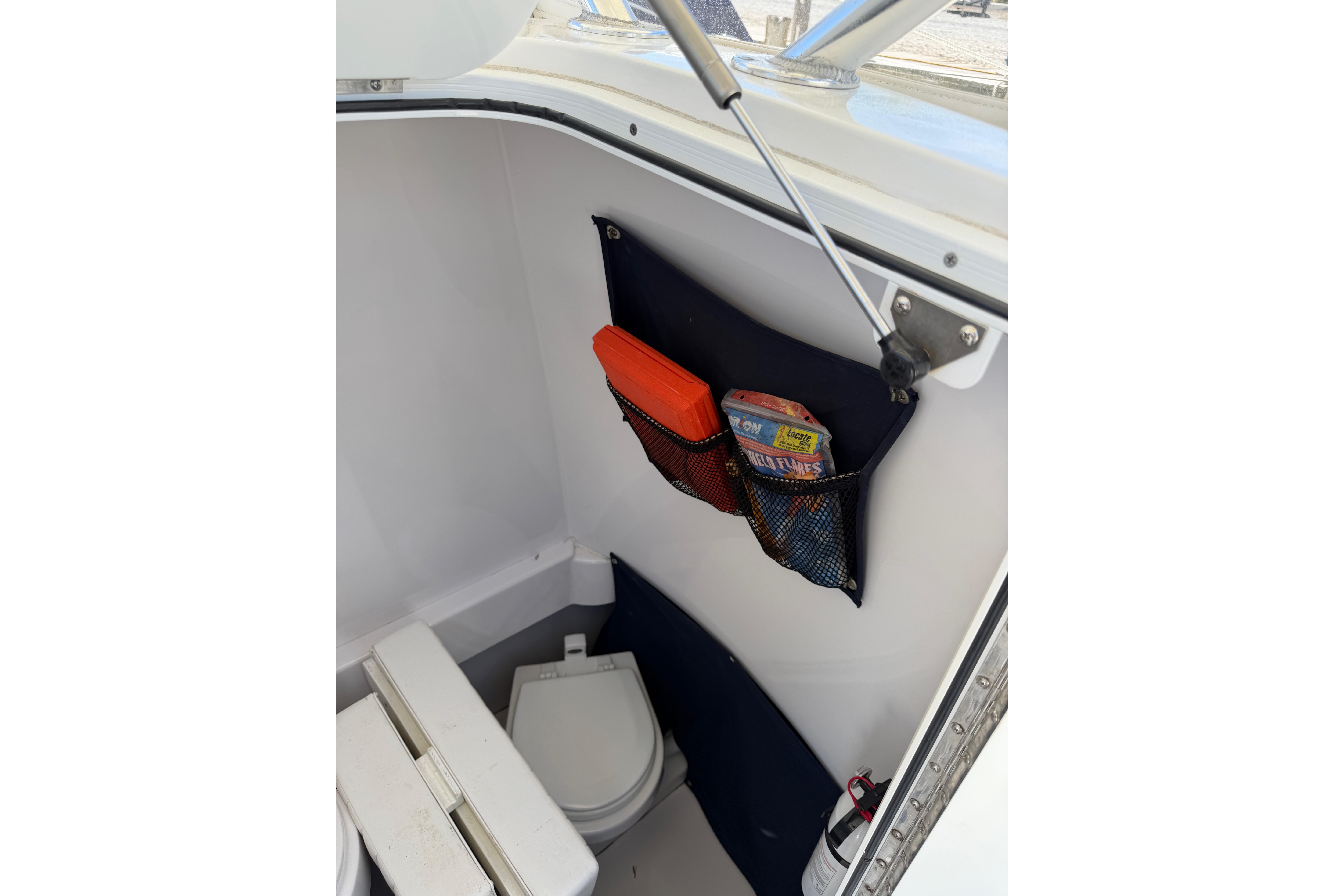 Interior of 2006 Southport 26 Center Console boat with storage and toilet.