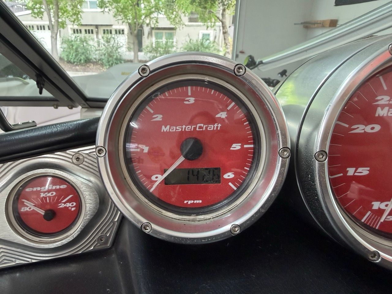 Close-up of MasterCraft X30 dashboard with red gauges and tachometers.