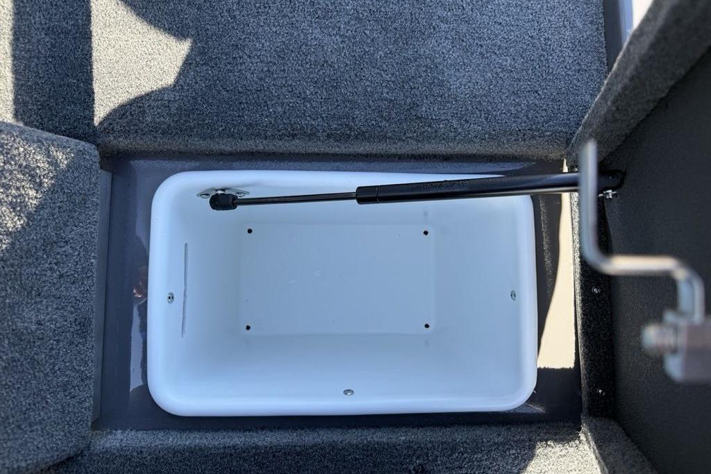 Interior storage compartment of 2026 Skeeter ZX150 boat, featuring a white container and hydraulic lift.