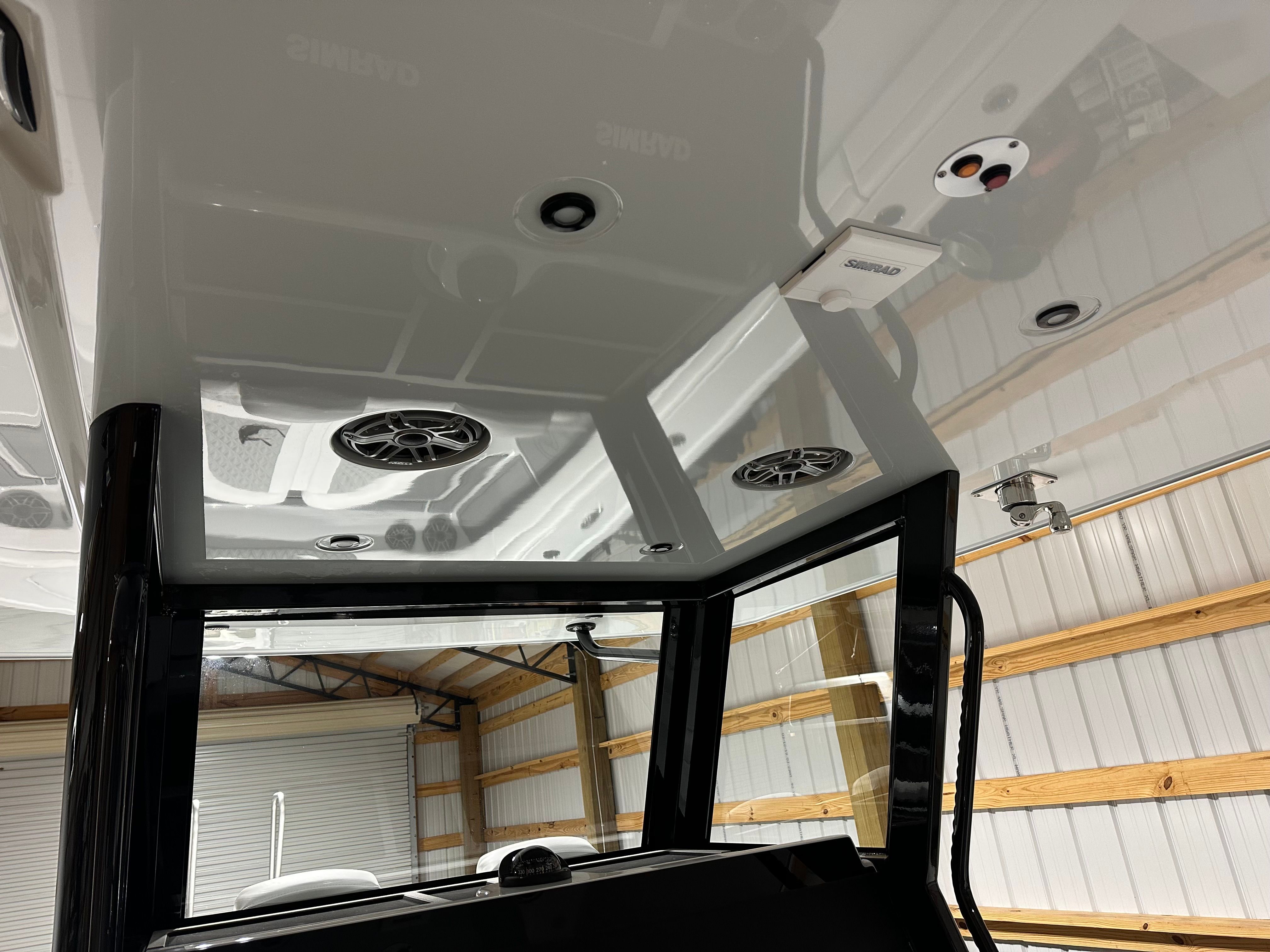 The image shows the interior of a boat with speakers and lights on the ceiling.