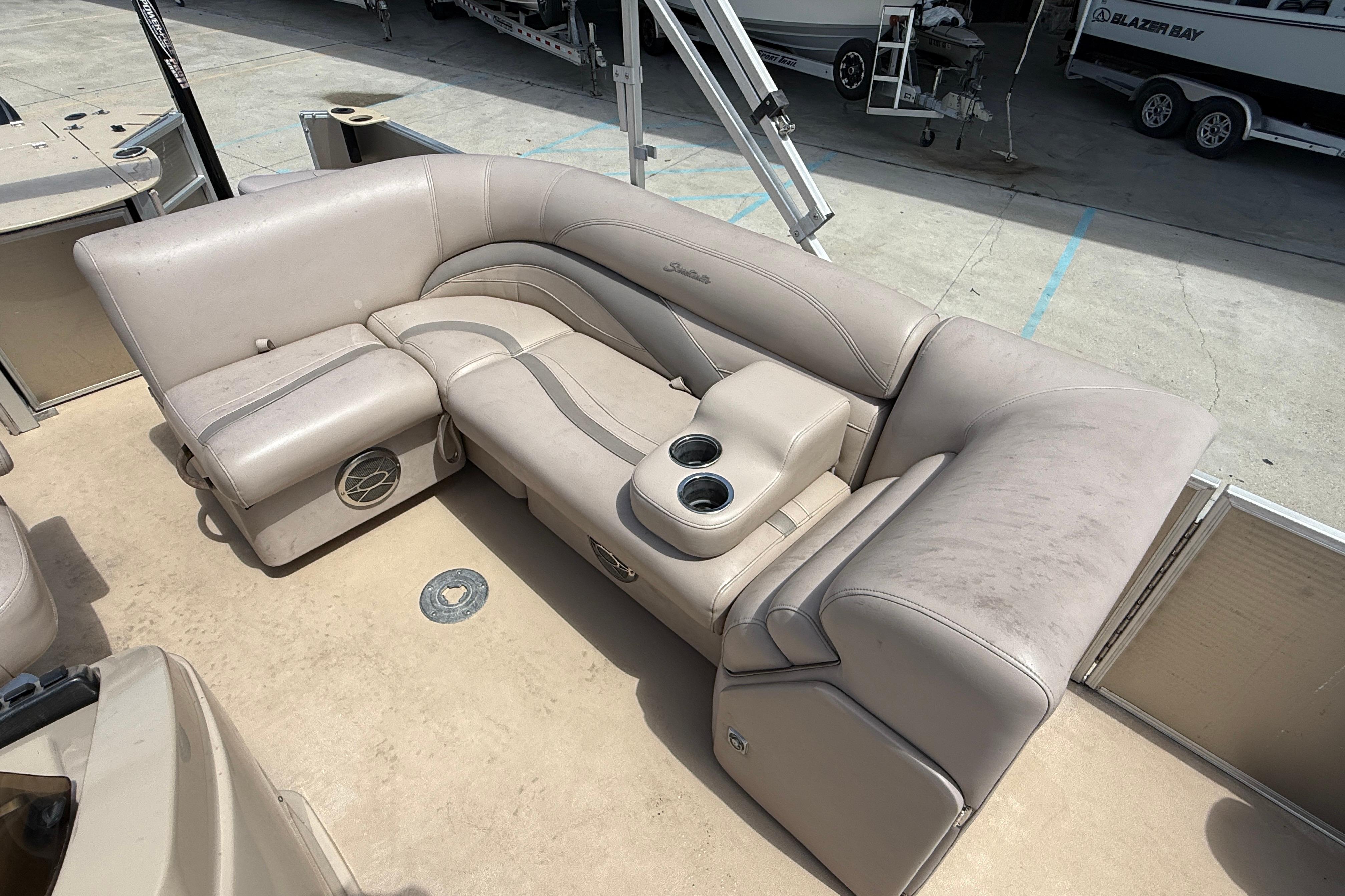 2014 Godfrey Sweetwater 2486 C pontoon boat seating with cup holders, beige upholstery.