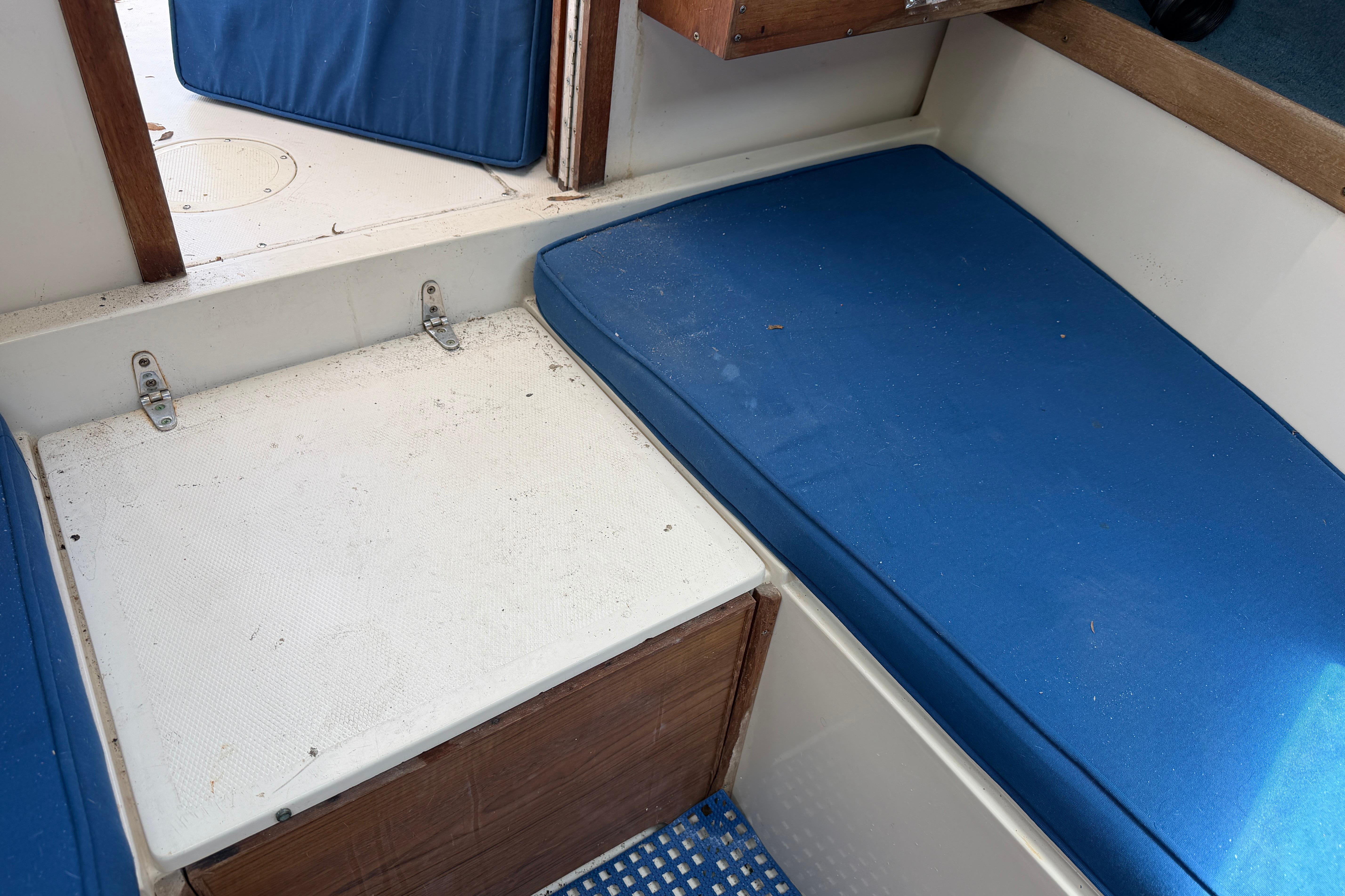 Interior of 1987 Grady-White Seafarer 226 boat with blue cushions and wooden accents.