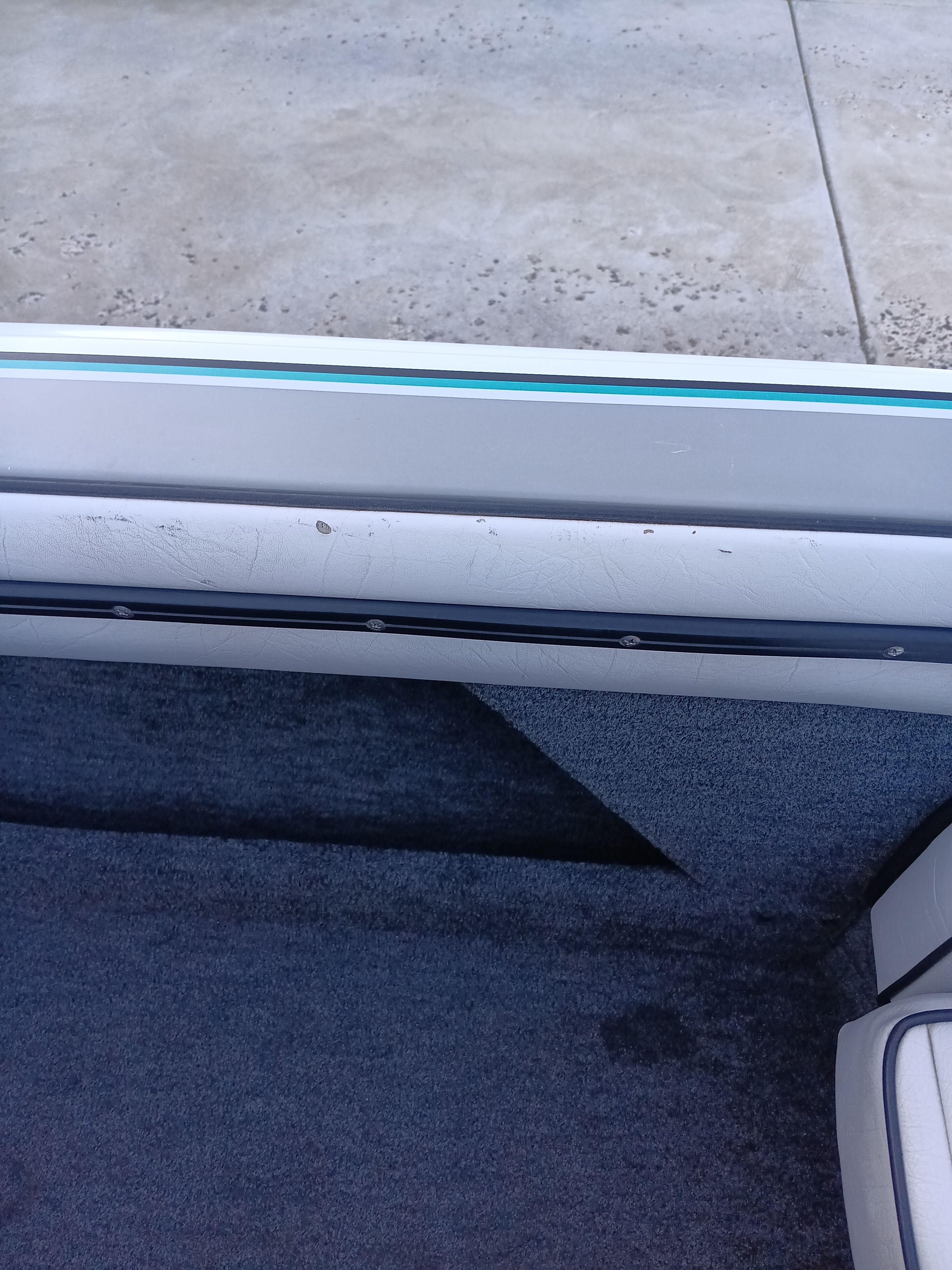 Interior of a 1991 Malibu Skier boat with gray carpet.