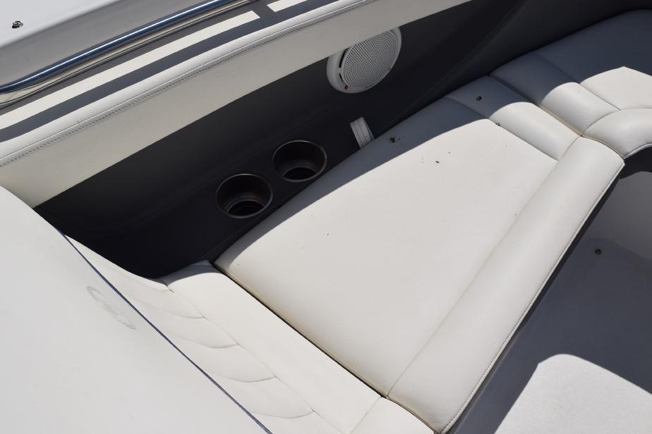 Interior seating of a 2006 Cobalt 240 boat with cup holders and speaker.