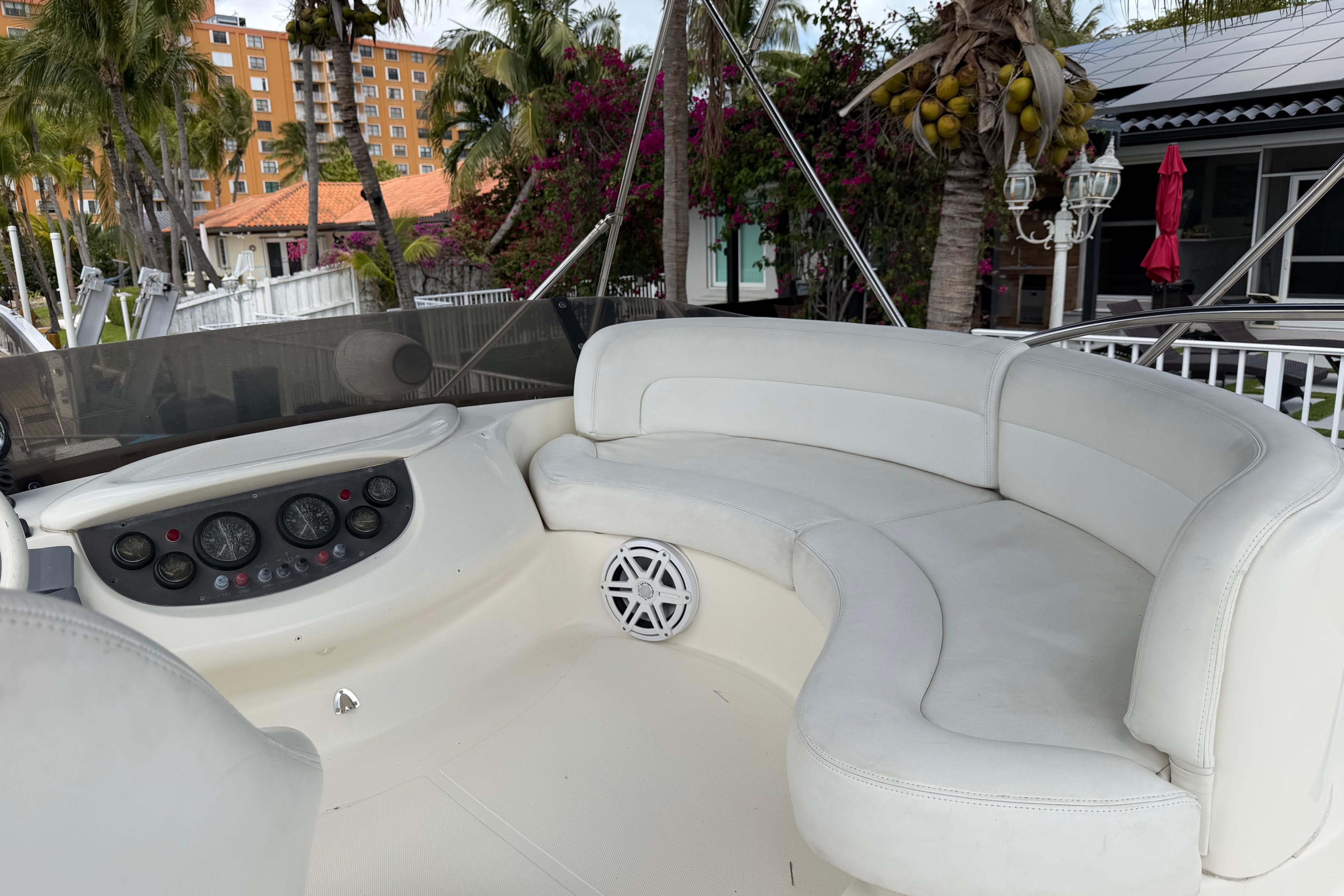 Luxurious 2004 Azimut 39E yacht interior with white seating and control panel.