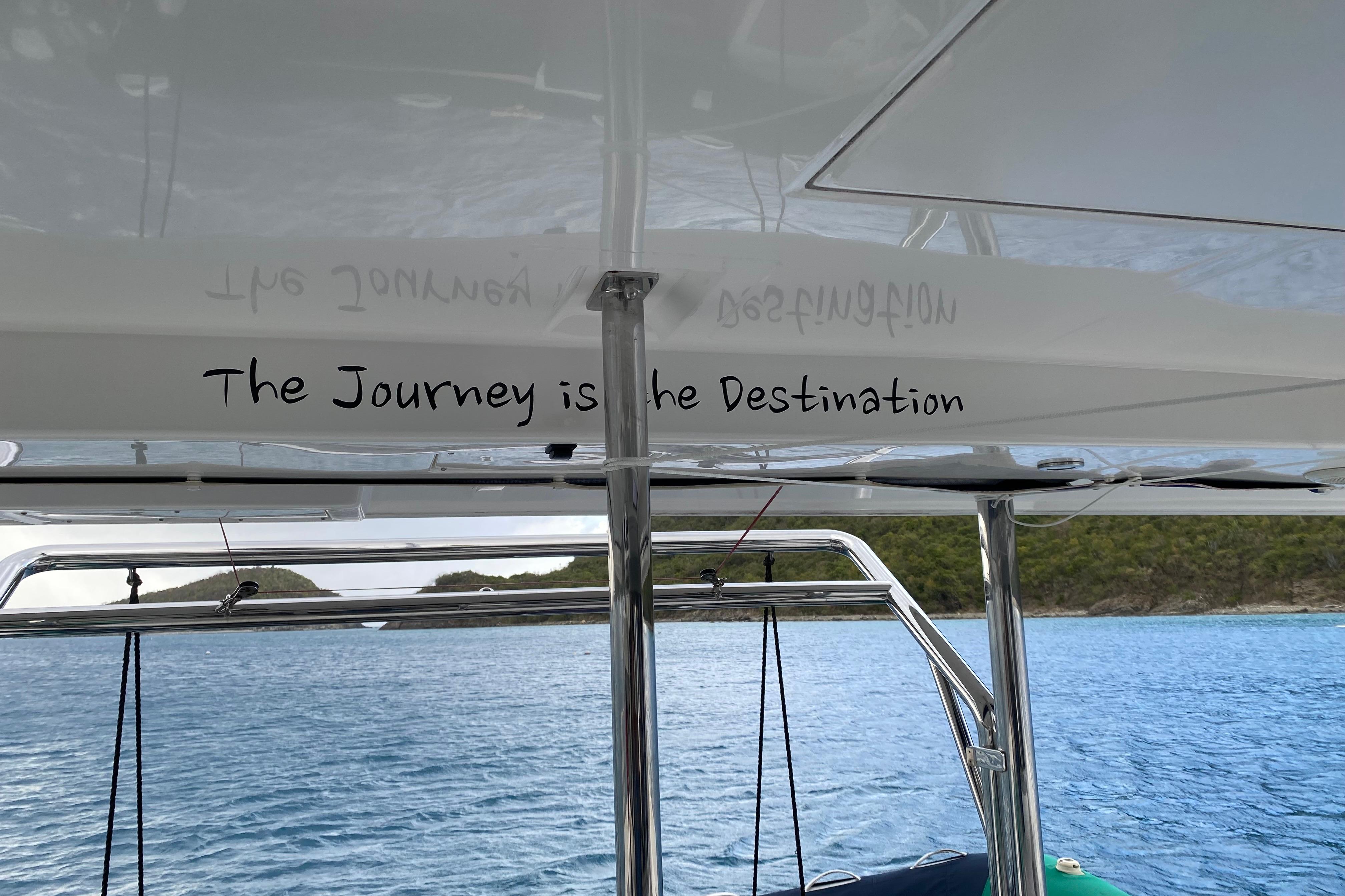 Leopard 40 catamaran with "The Journey is the Destination" text, sailing in scenic waters.