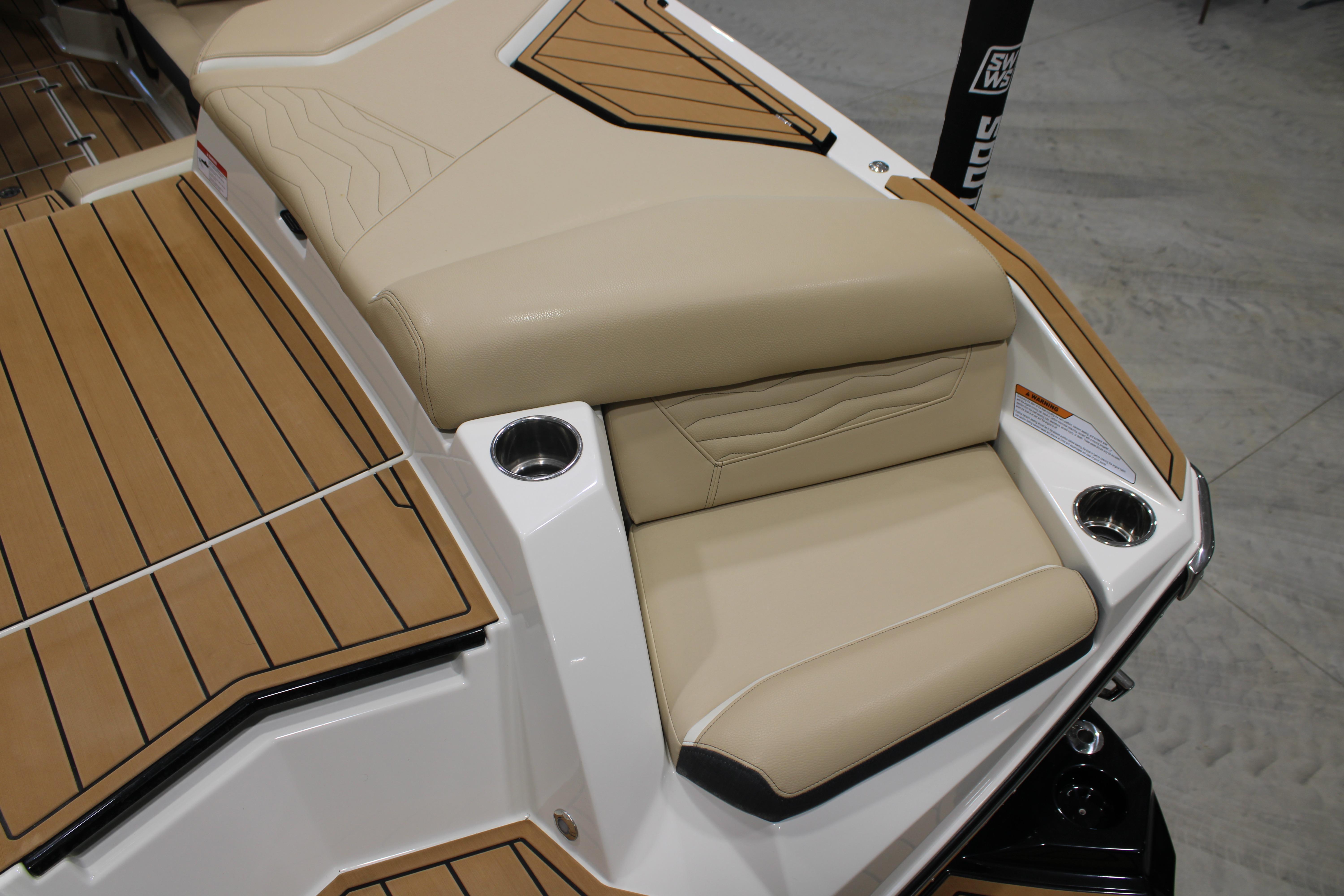 2025 Nautique Super Air Nautique G25 boat interior with beige seating and cup holders.