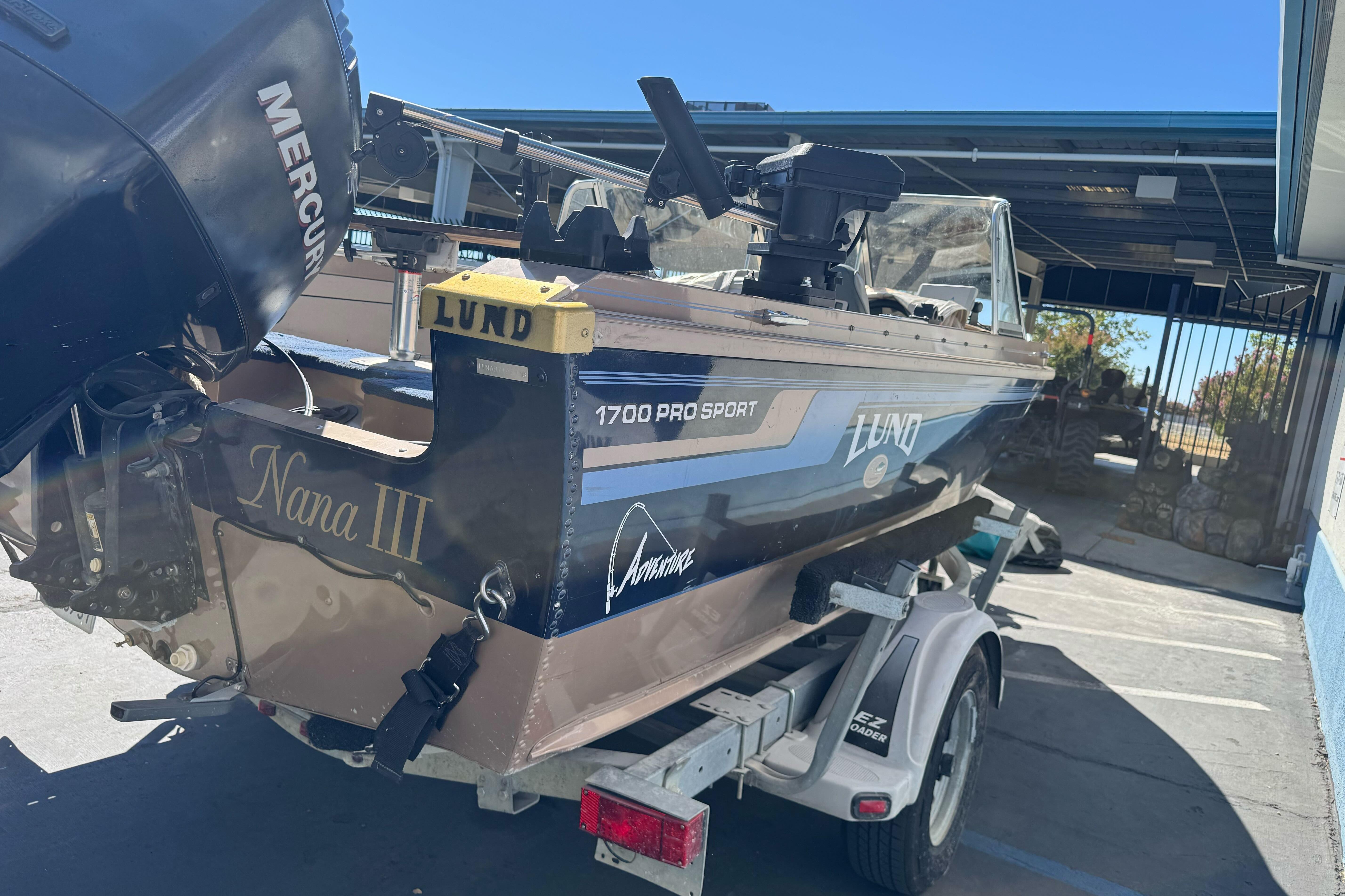1998 Lund 1700 Pro Sport boat on trailer, featuring Mercury outboard motor.