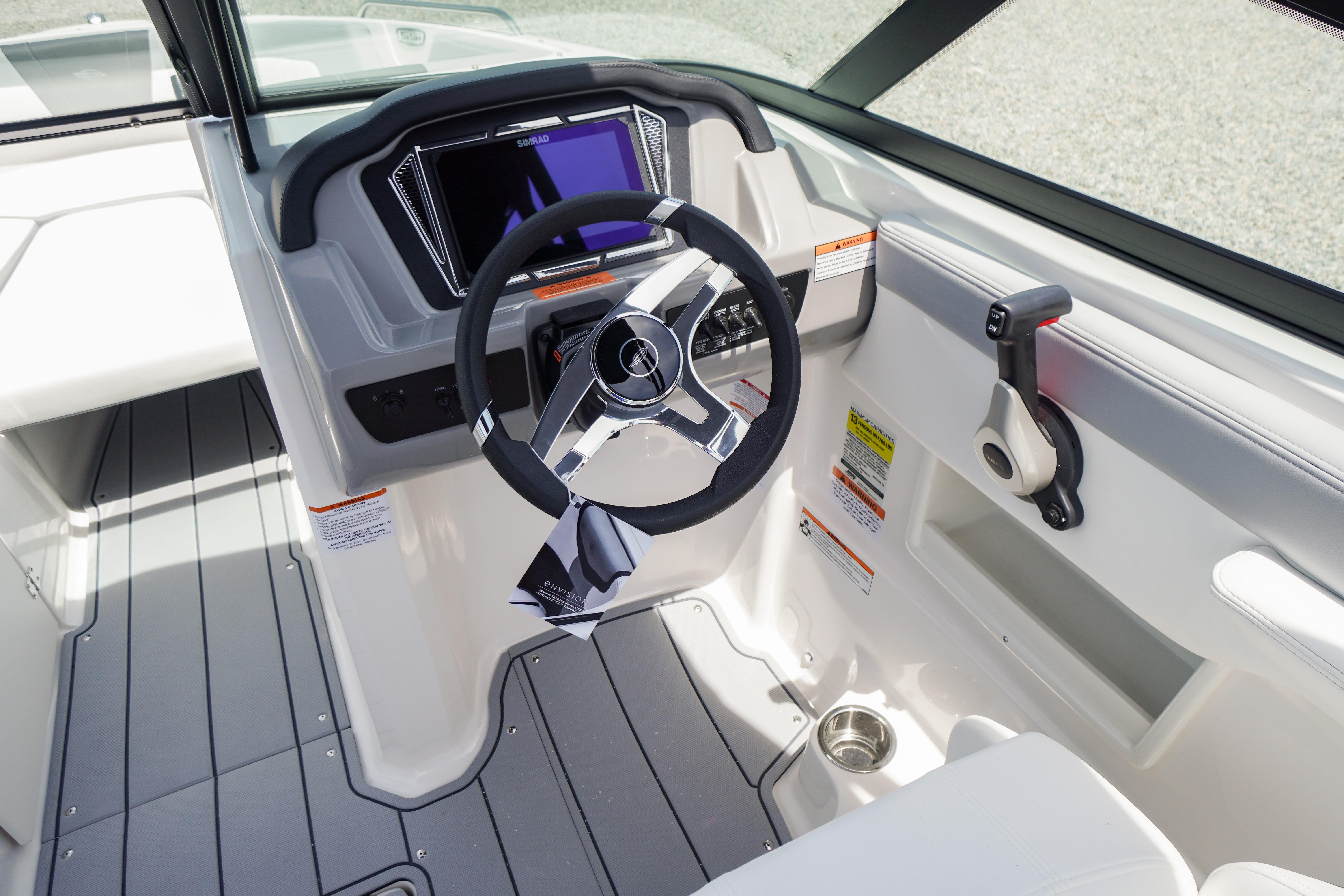 2026 Chaparral 23 SSi OB boat cockpit with steering wheel and control panel.