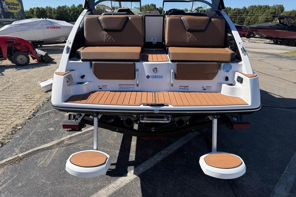 2026 Yamaha Boats 252SD with brown seating and swim platform, displayed outdoors.