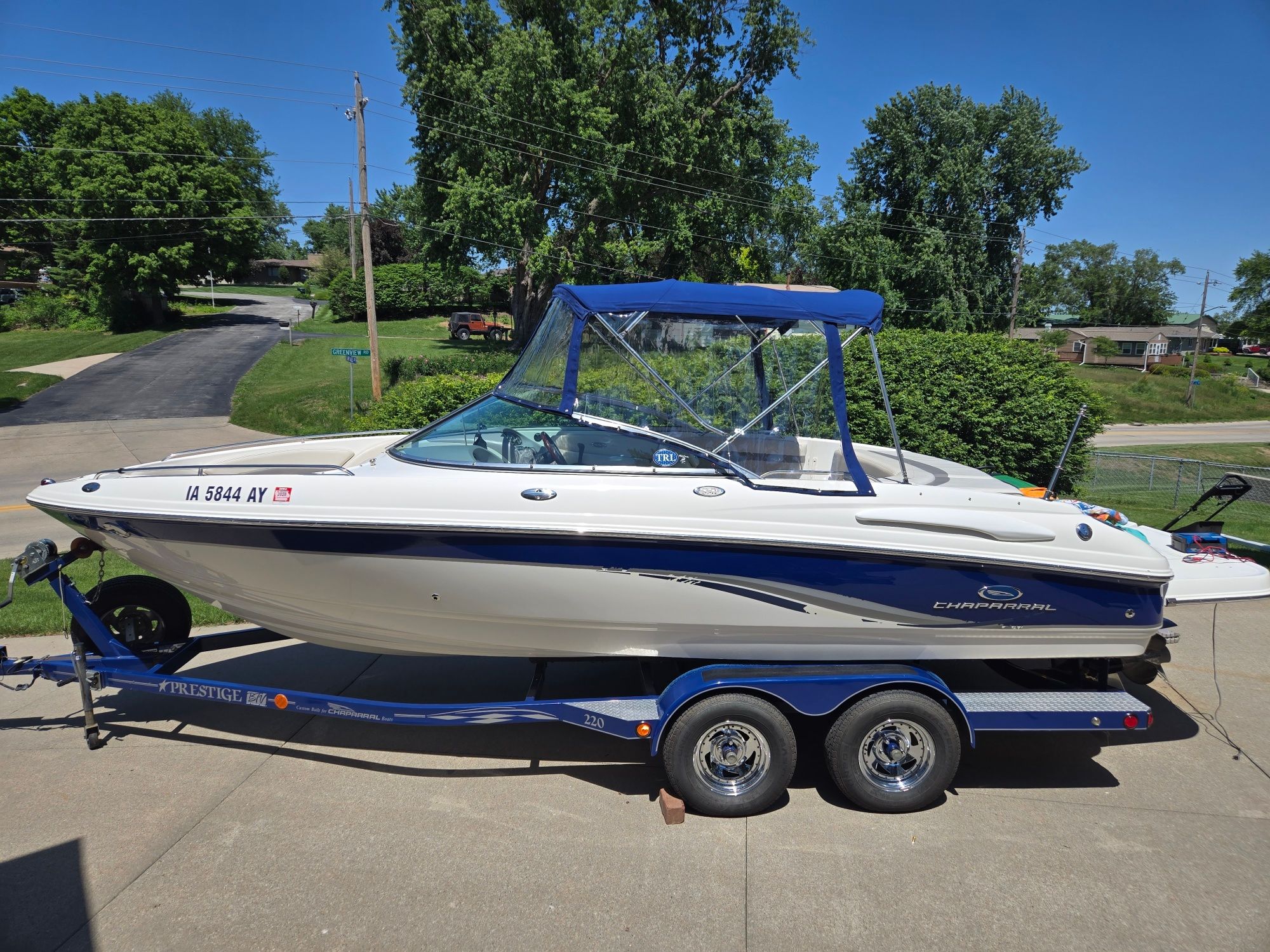 A 2005 Chaparral 220 SSi boat on a trailer, parked on a driveway.