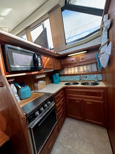 Carver 3807 Aft Cabin Yacht kitchen, 1988 model, featuring wood cabinets and appliances.