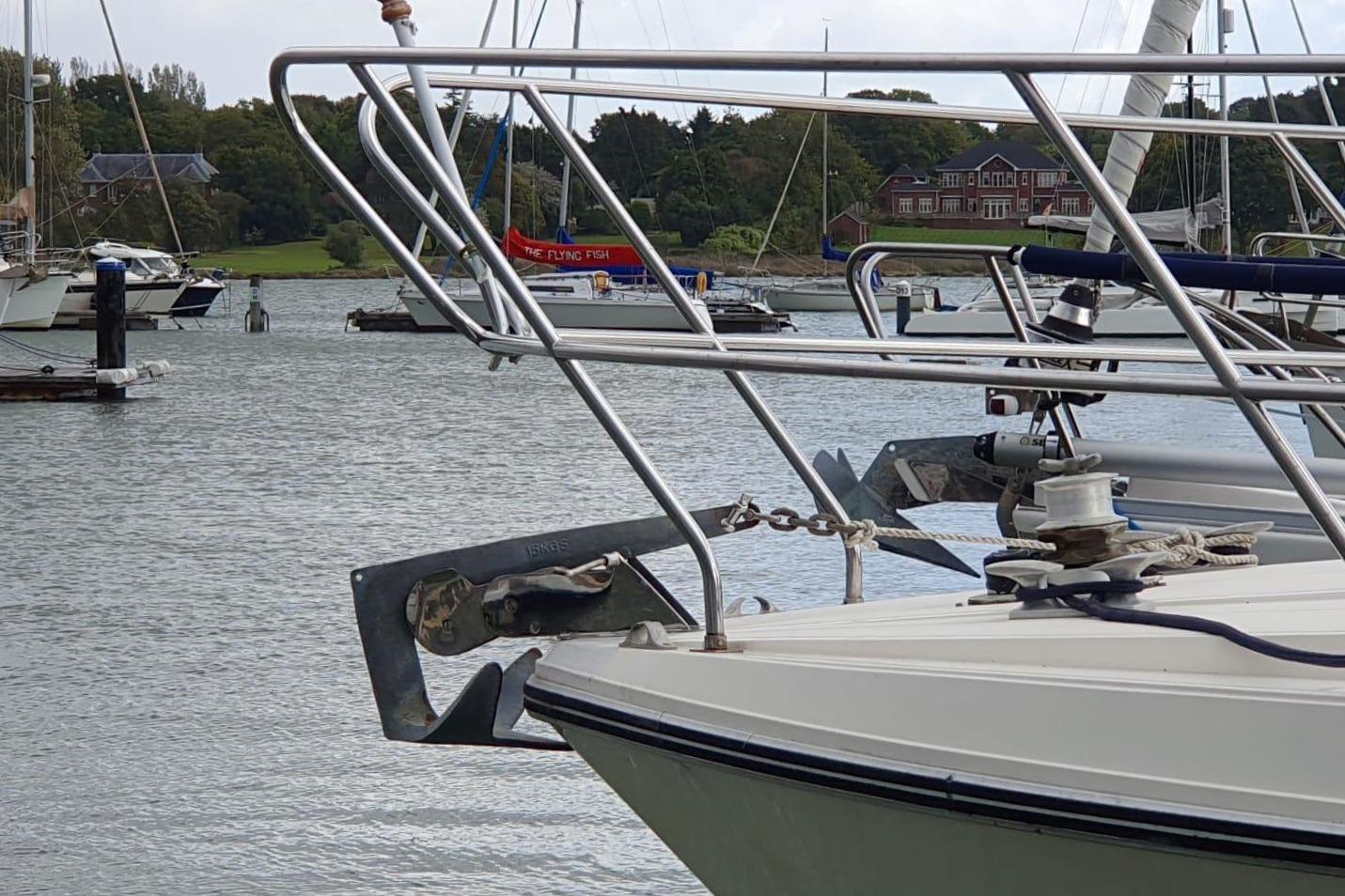 Bow of a 1989 Princess 35 yacht with anchor in a marina.
