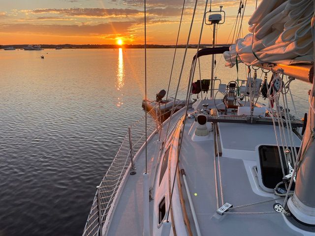 Sunset on a 1989 Catalina 34 sailboat, on calm water with a clear view of the deck.